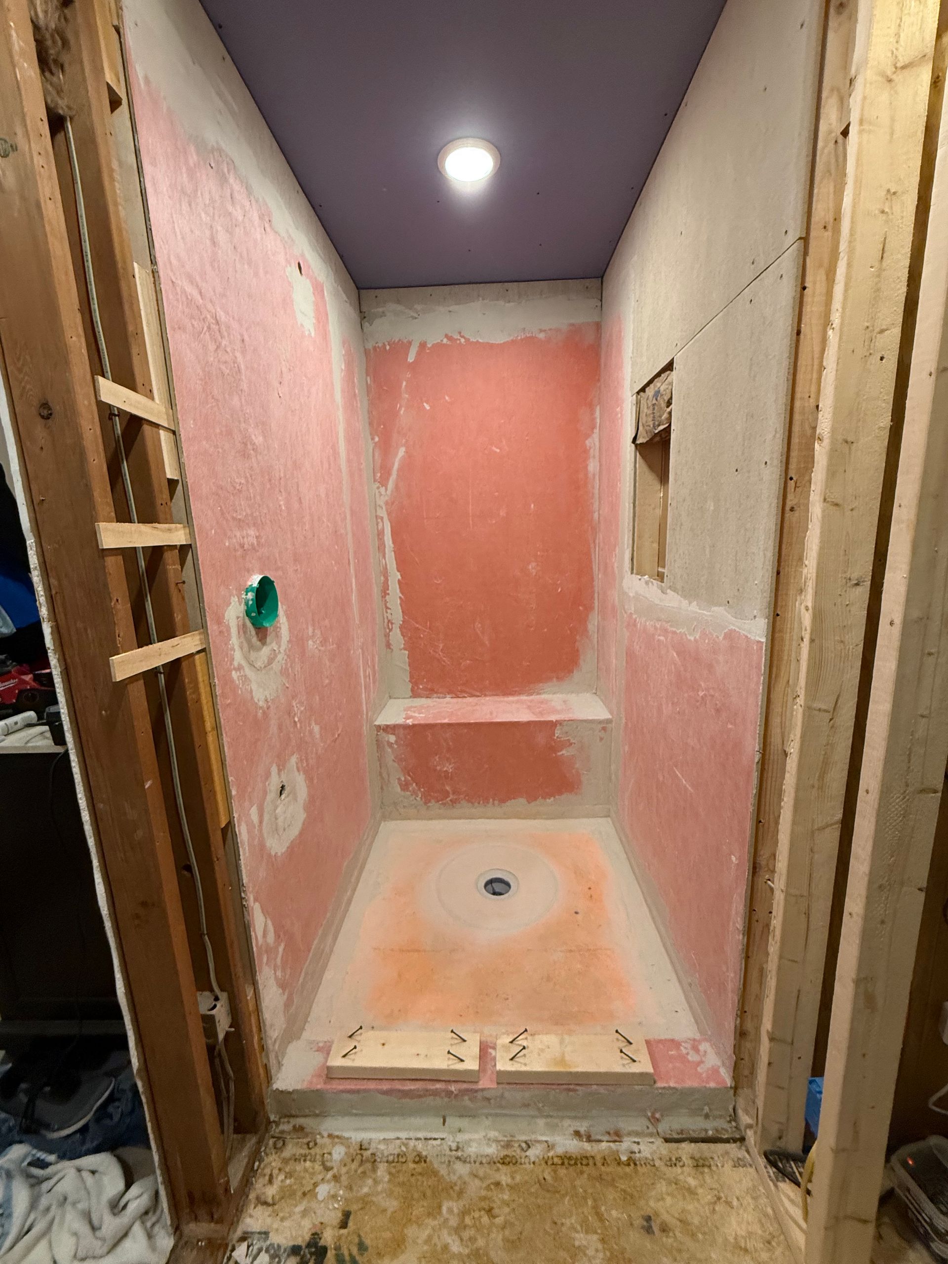 A shower stall is being built in a bathroom.