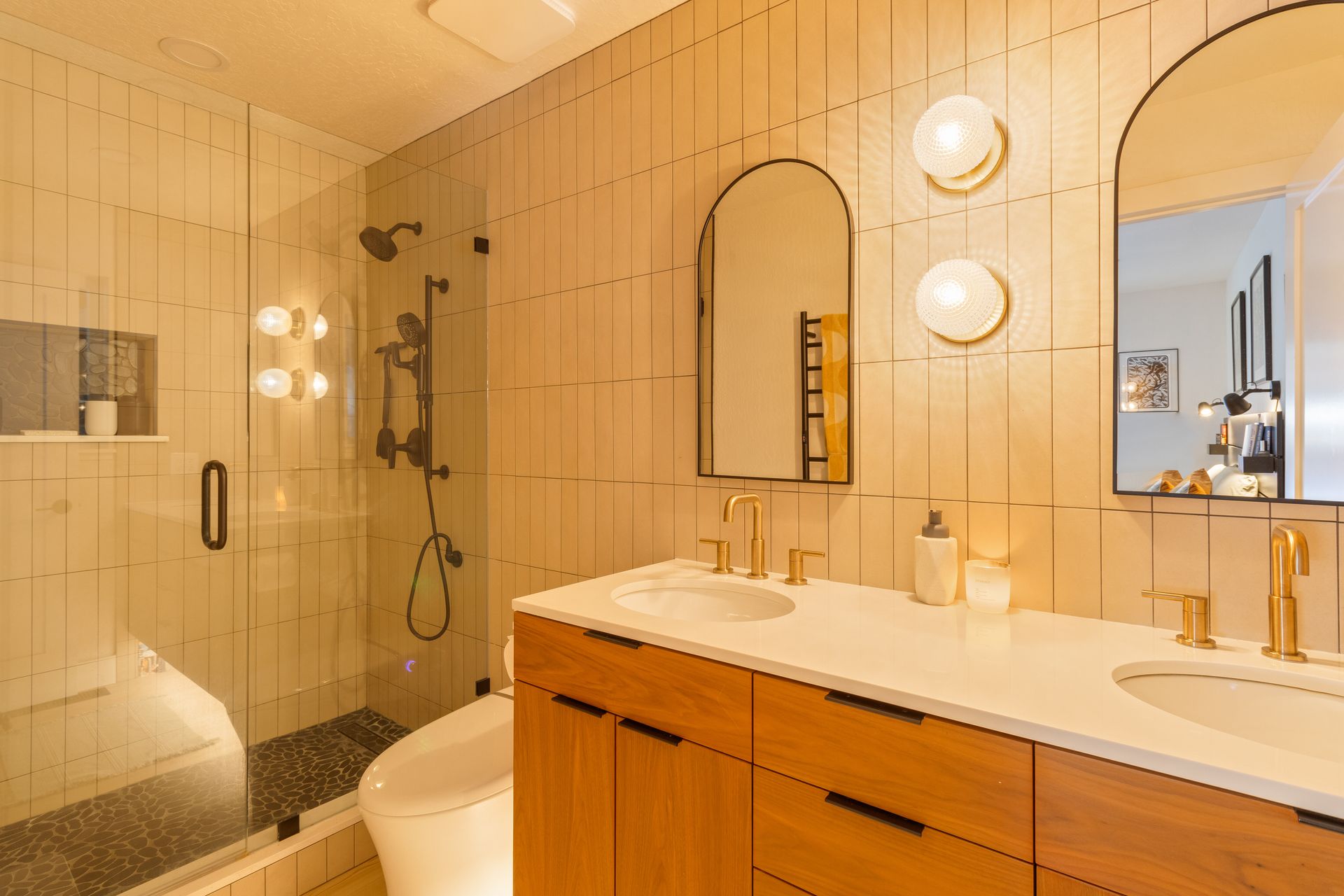 A bathroom with two sinks , a toilet , and a shower.