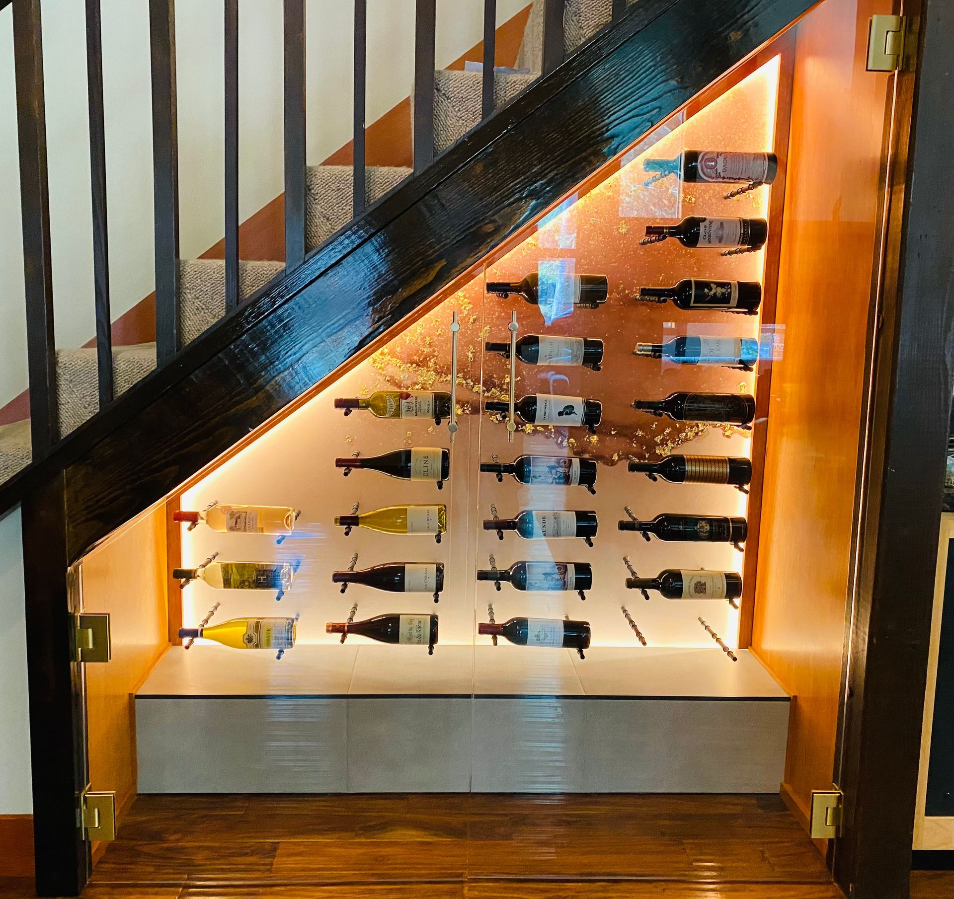 Bottles of wine are displayed under a staircase