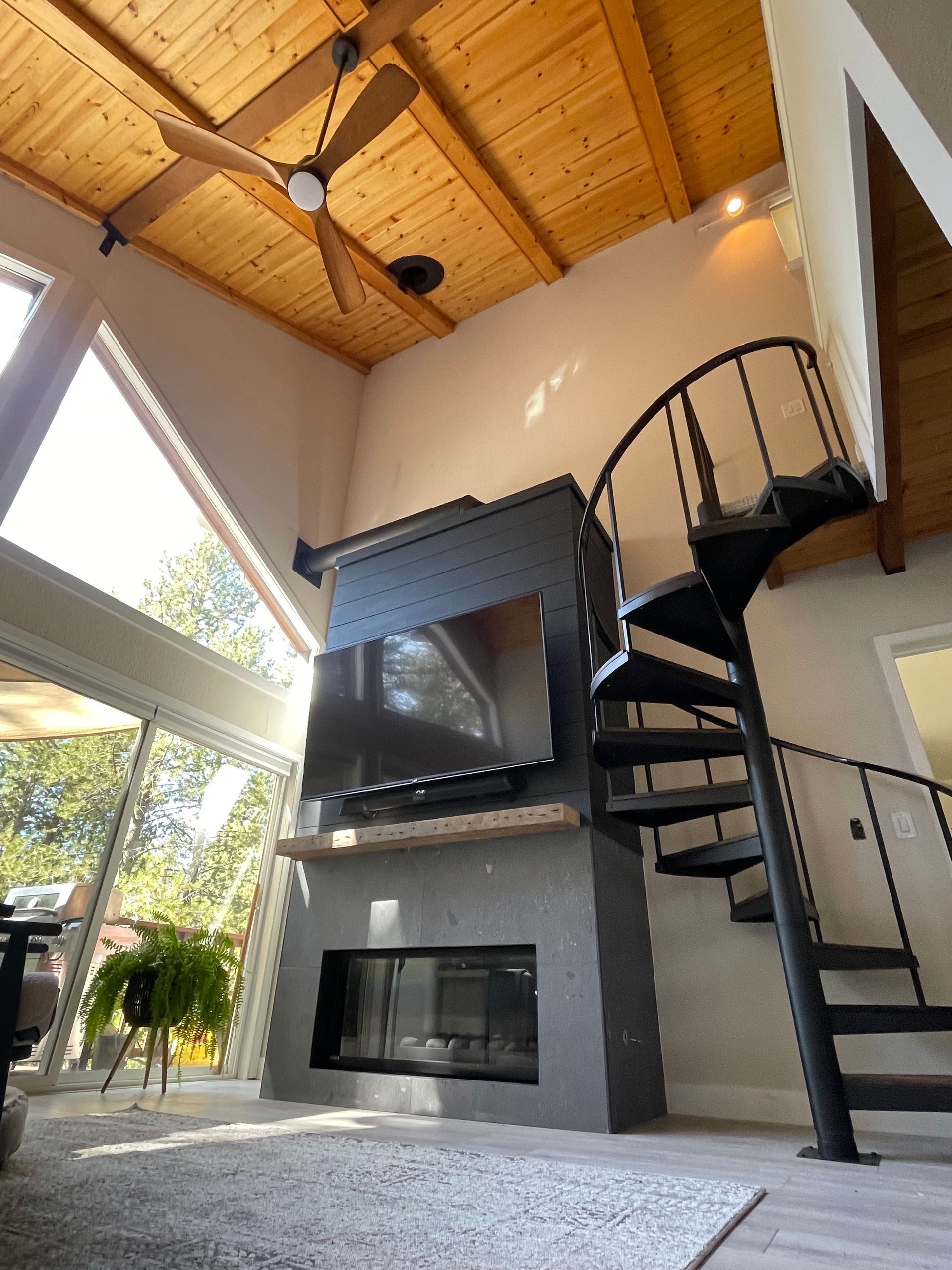 A living room with a spiral staircase and a fireplace