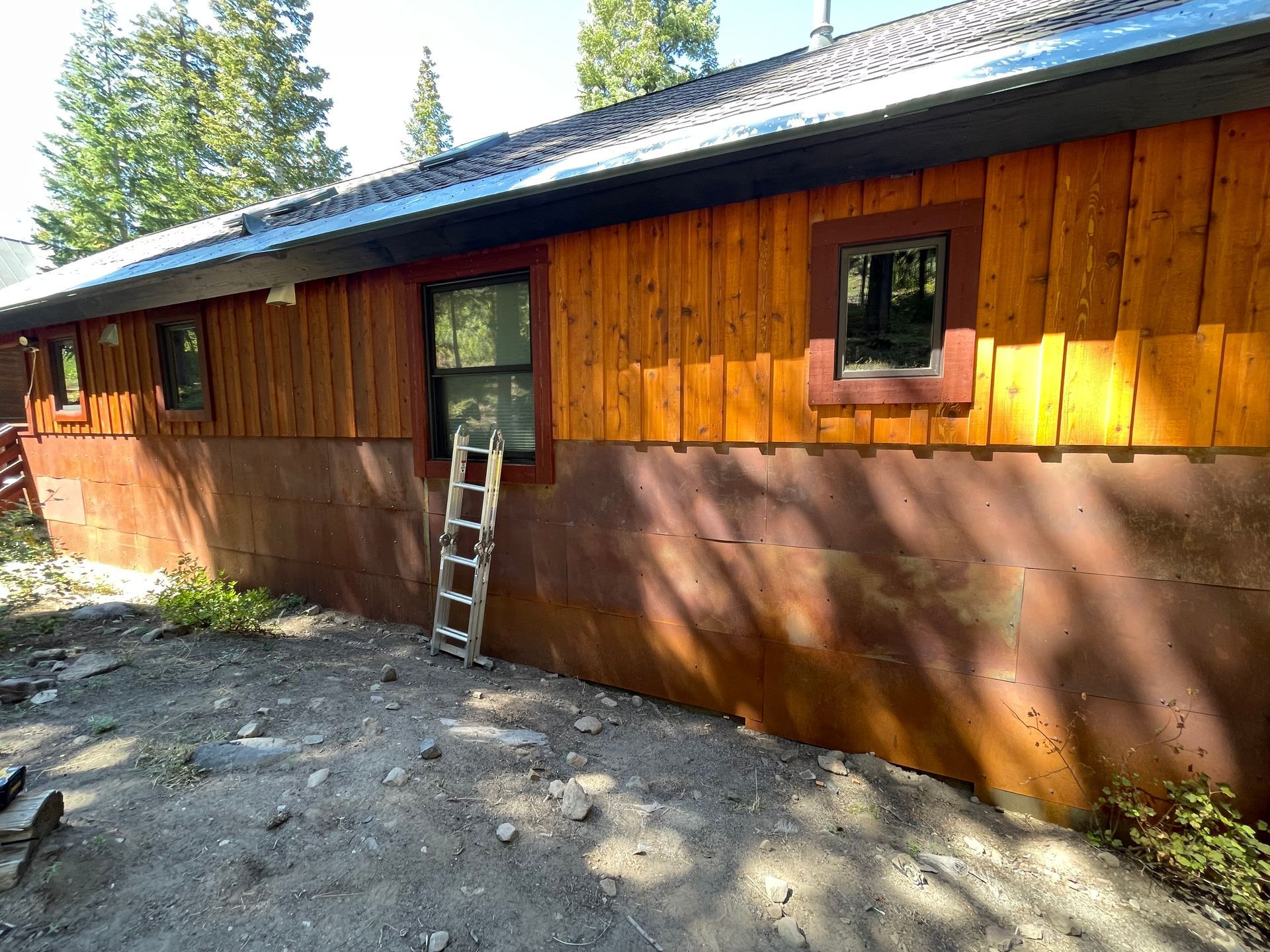 A house with wooden siding and a ladder on the side of it.
