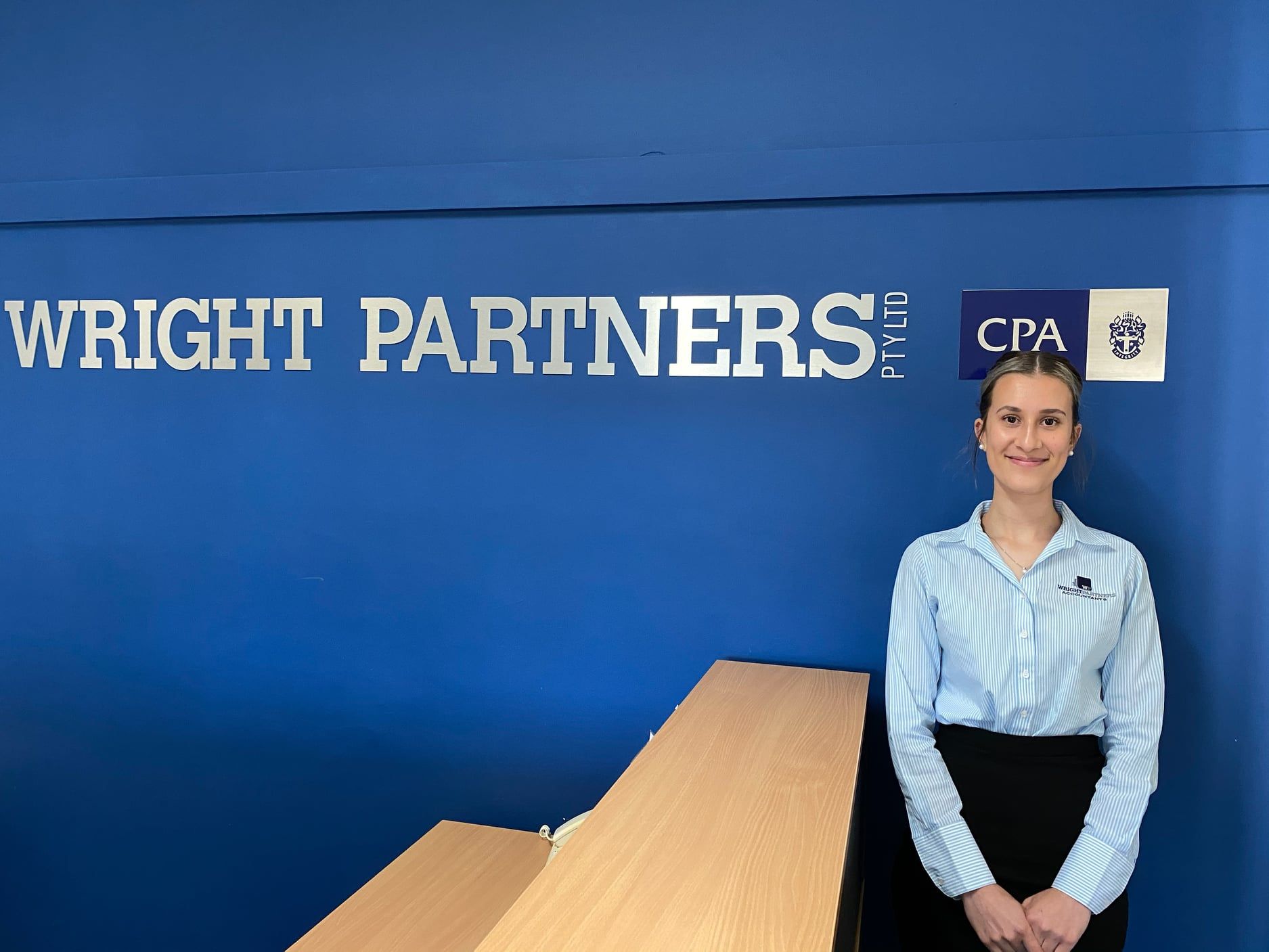 Woman in Professional Attire Stands in Front of Wright Partners Sign — Wright Partners in Dubbo, NSW