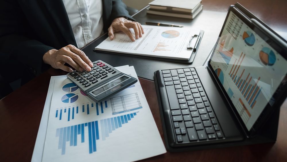 Person Using a Calculator, Analyzing Charts and Graphs, and Reviewing Data — Wright Partners in Dubbo, NSW