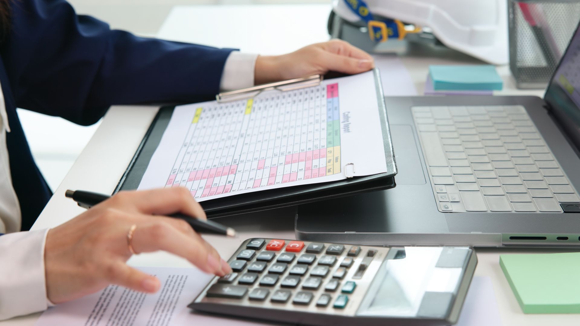 Person Using Calculator, Reviewing a Document on A Clipboard — Wright Partners in Bourke, NSW