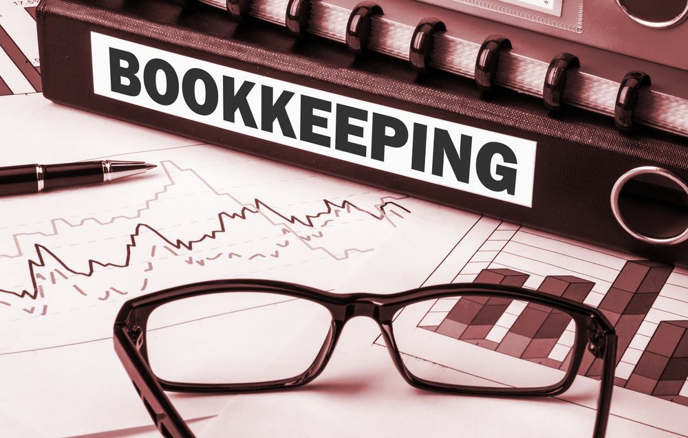 Bookkeeping Folder with Glasses and Pen on Charts — Wright Partners in Dubbo, NSW
