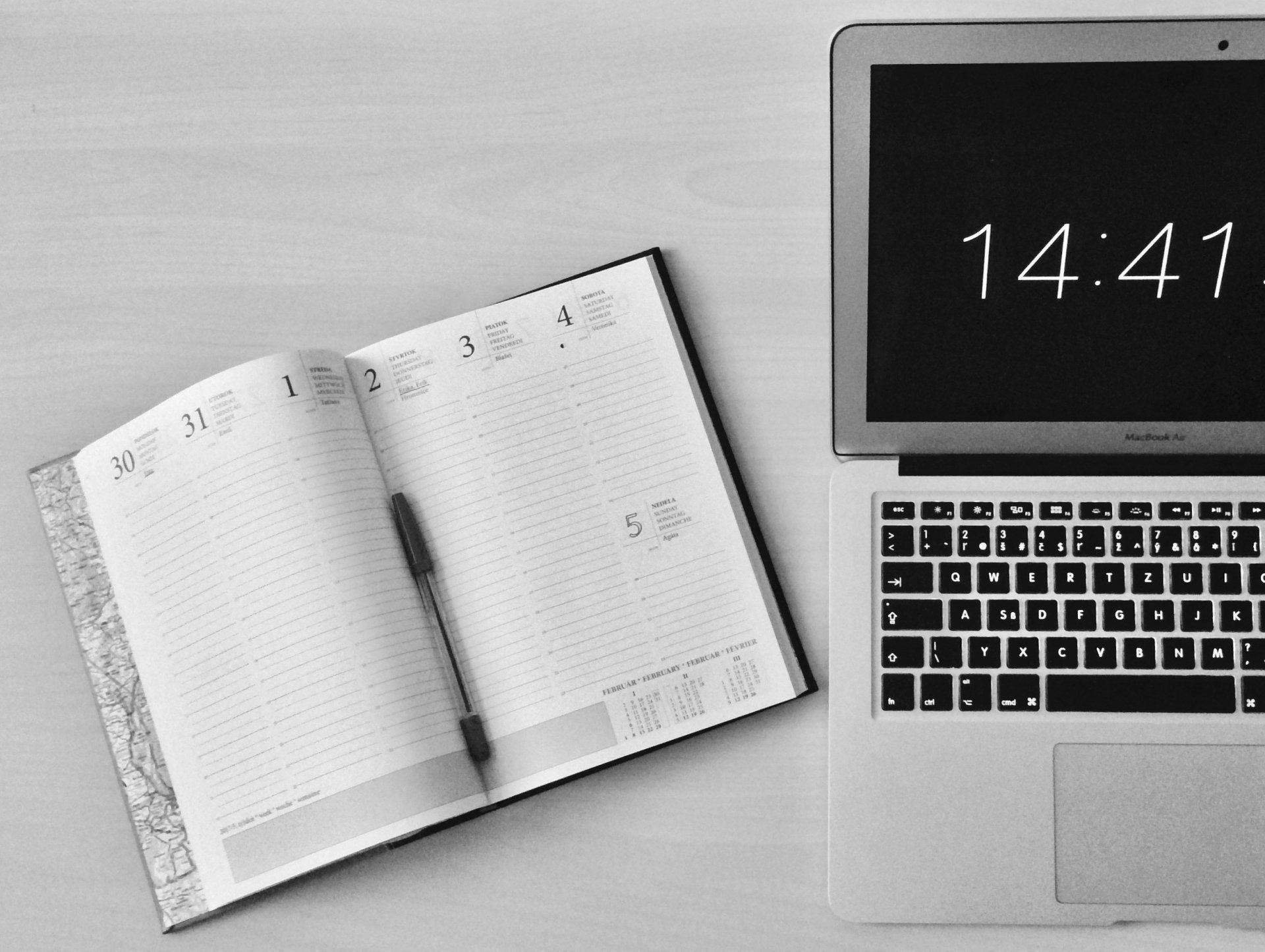 Laptop with Time Display and Open Planner with Pen on A Table — Wright Partners in Dubbo, NSW