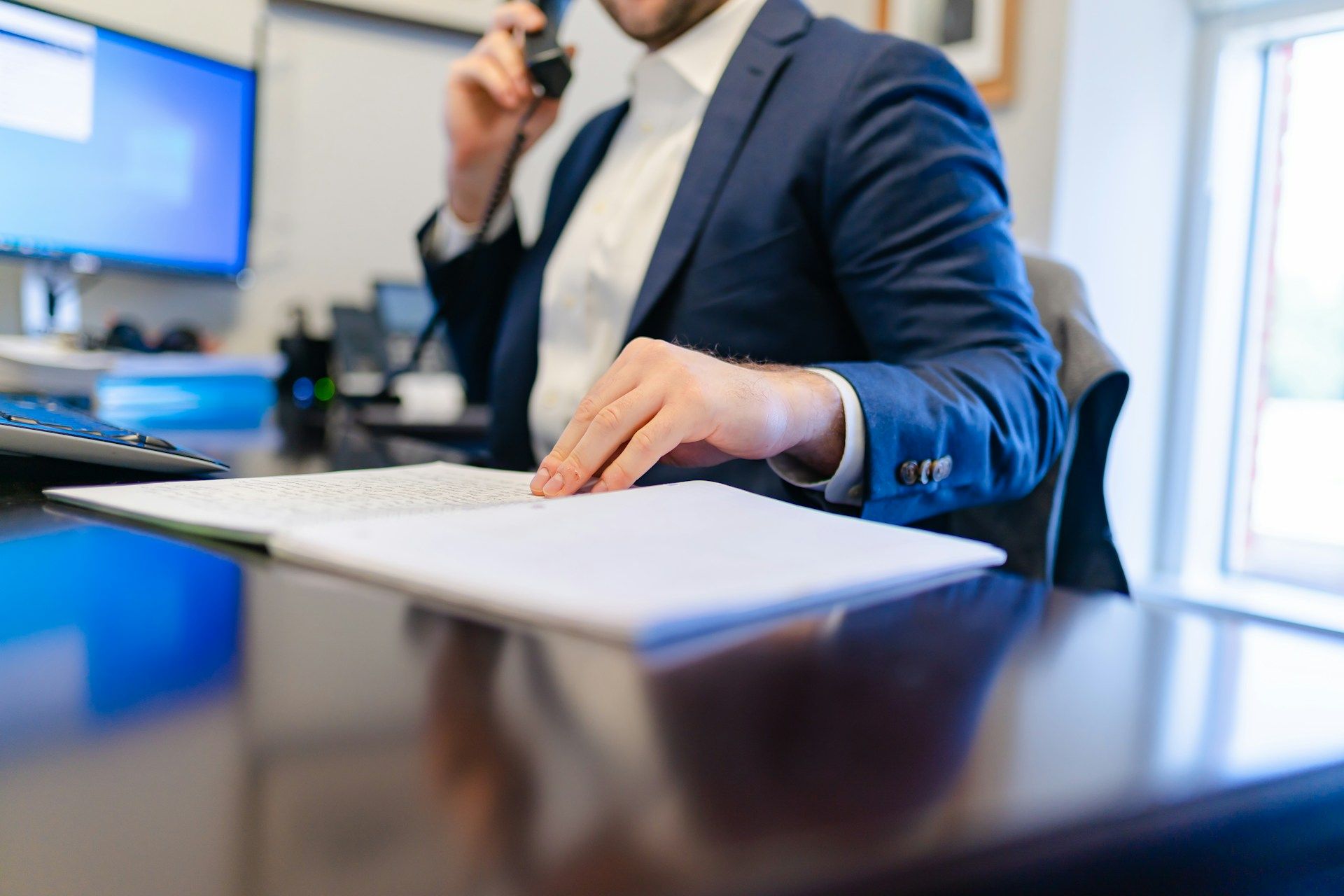 Businessperson signing a document at a desk in an office