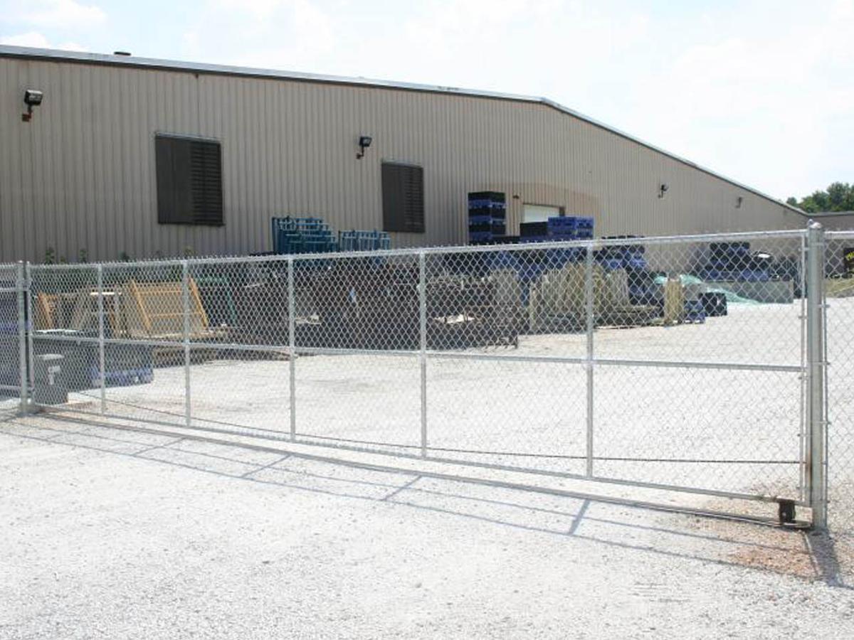 A chain link fence is in front of a large building