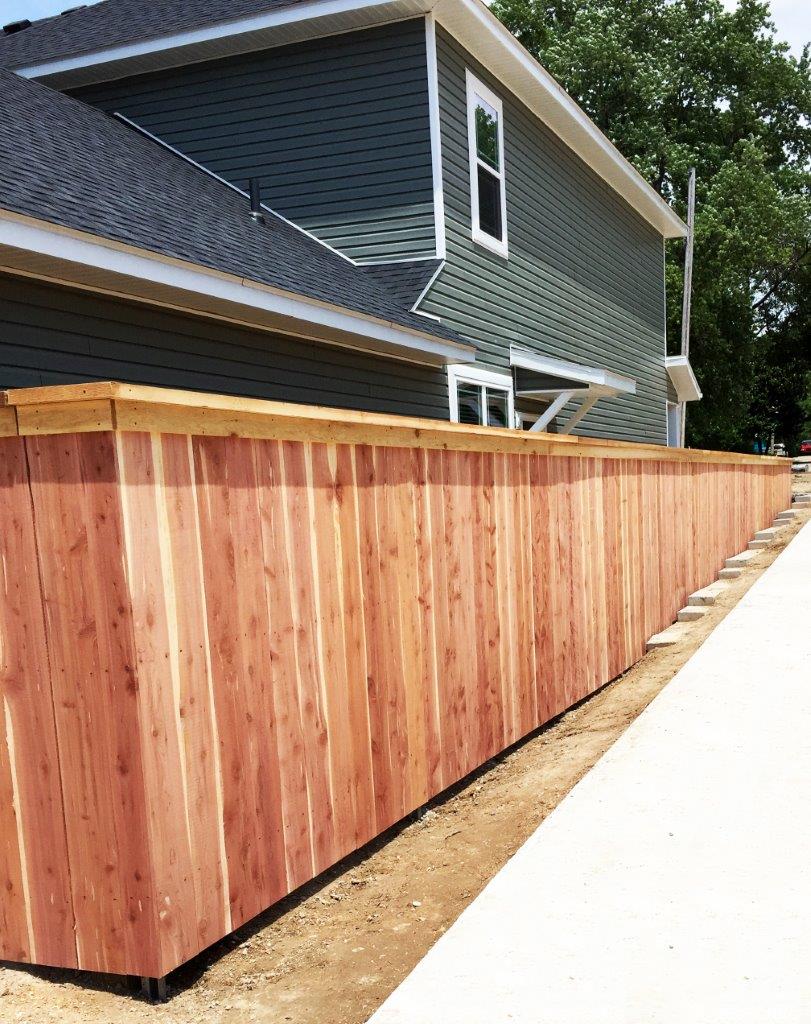 a wooden fence along the side of a house