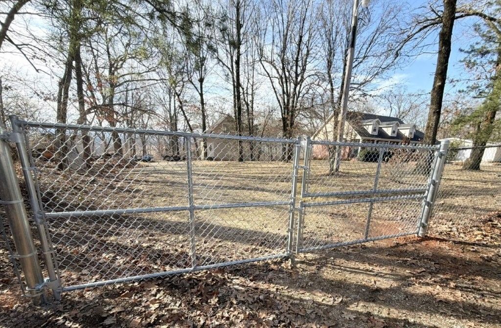 a black chain link fence surrounds a lush green yard