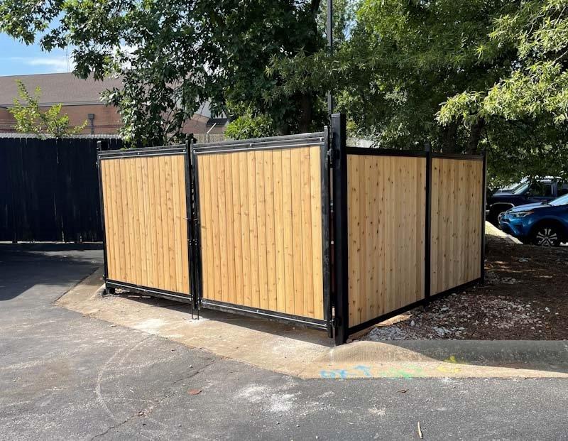 A wooden fence is sitting in the middle of a parking lot.