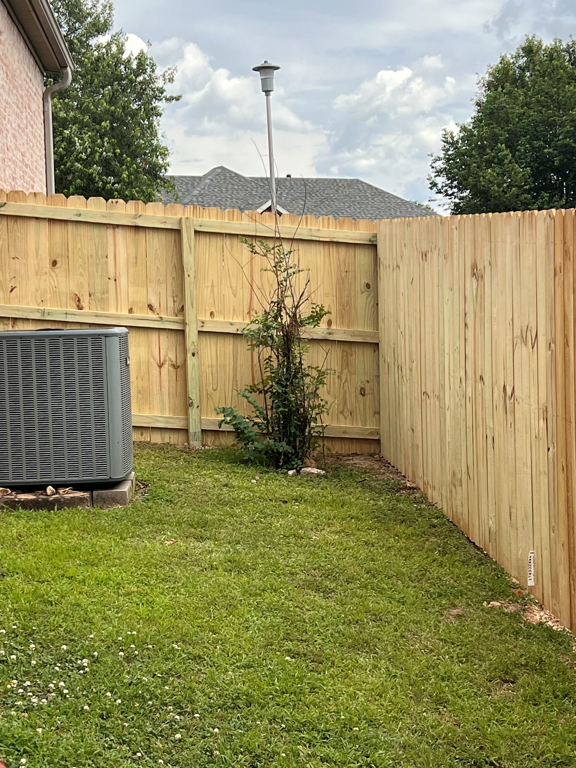 a wooden cedar fence with a gate in the middle