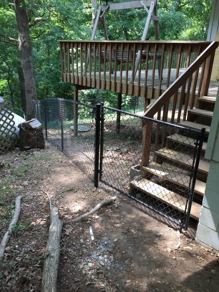a black chain link fence surrounds a wooden deck