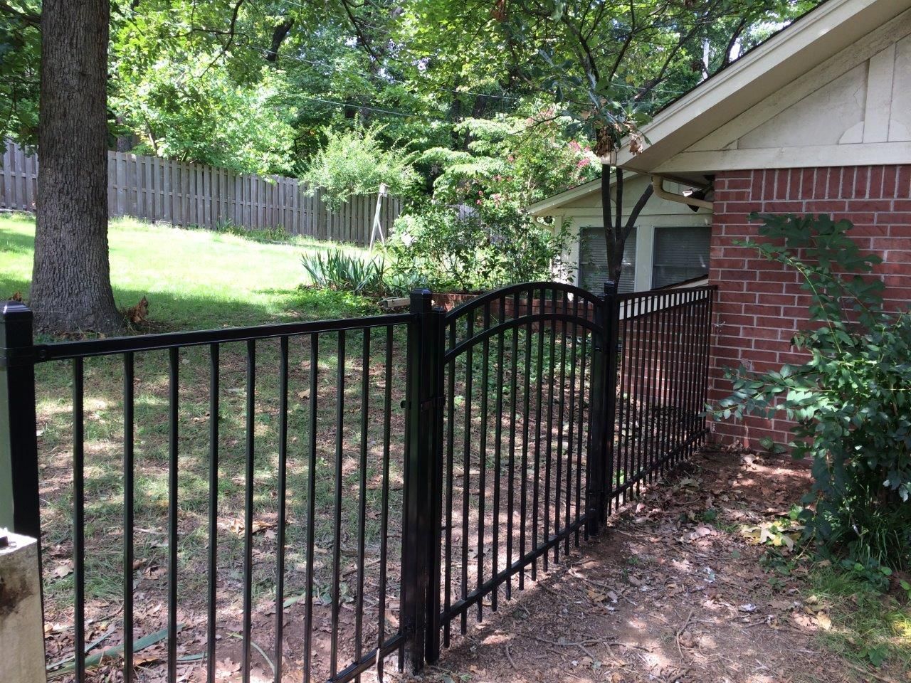 Arched ornamental iron walk gate installation in Northwest Arkansas