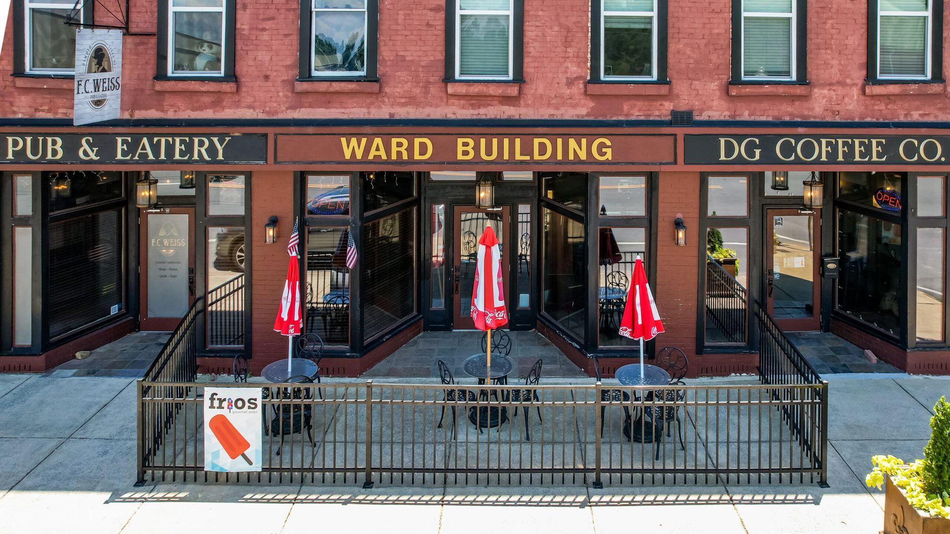 Exterior of a red brick building with businesses: 