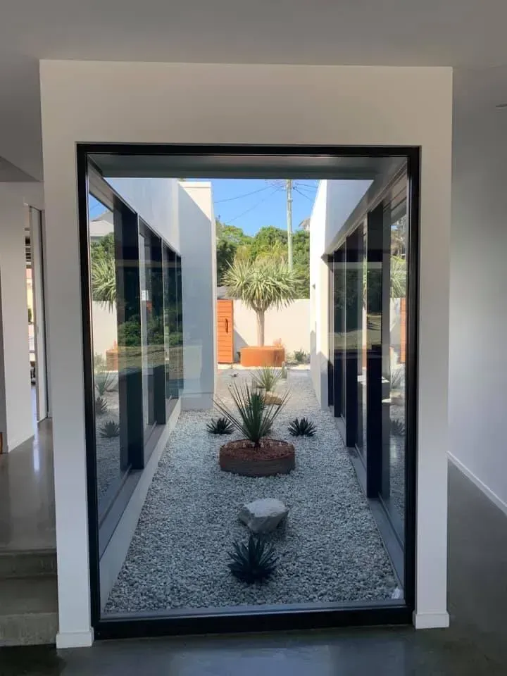 A View Through a Large Indoor Window Into a Minimalist — Creative Landscapes Coffs Harbour in Korora, NSW