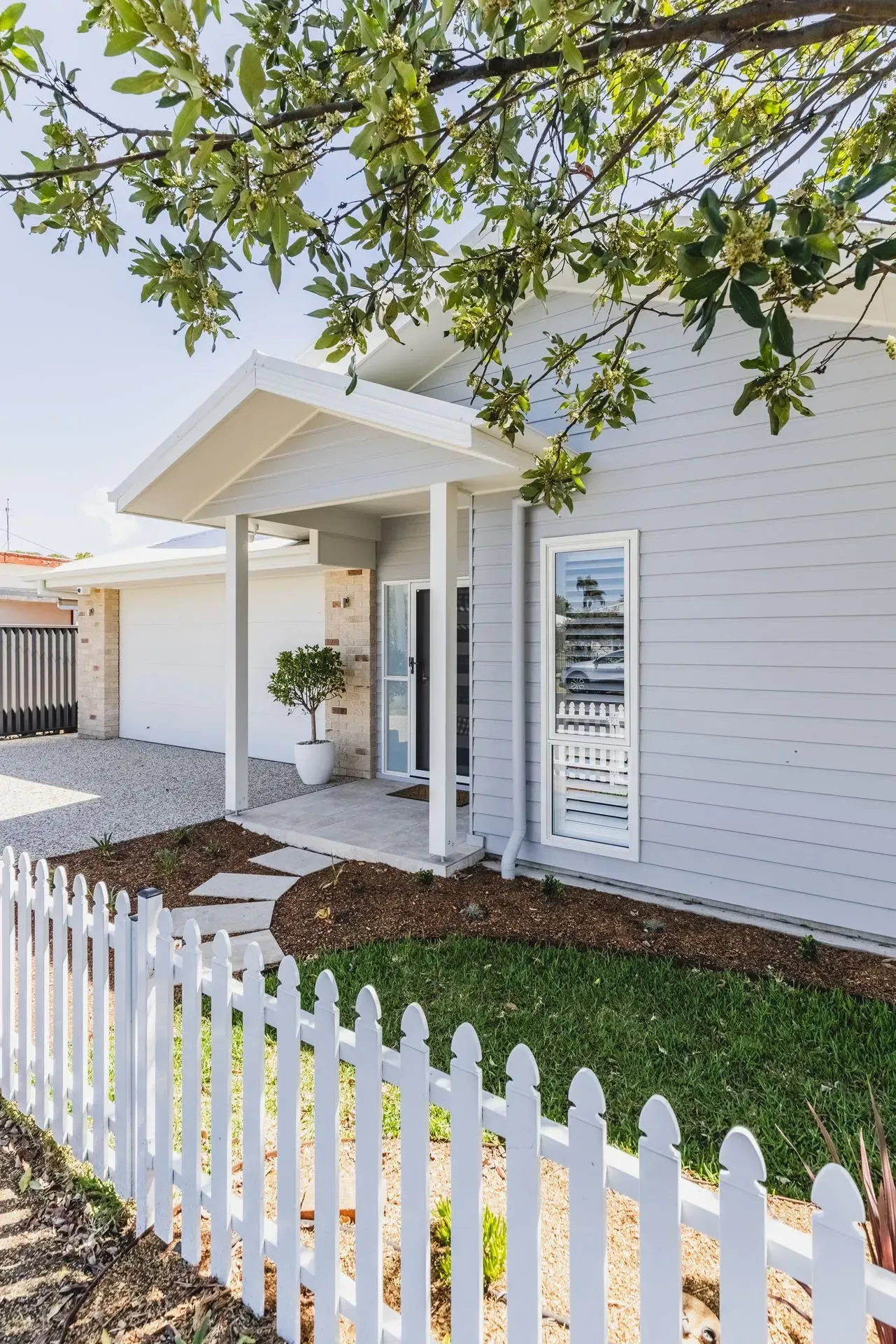 A Light Gray House with A White Picket Fence  — Creative Landscapes Coffs Harbour in Korora, NSW