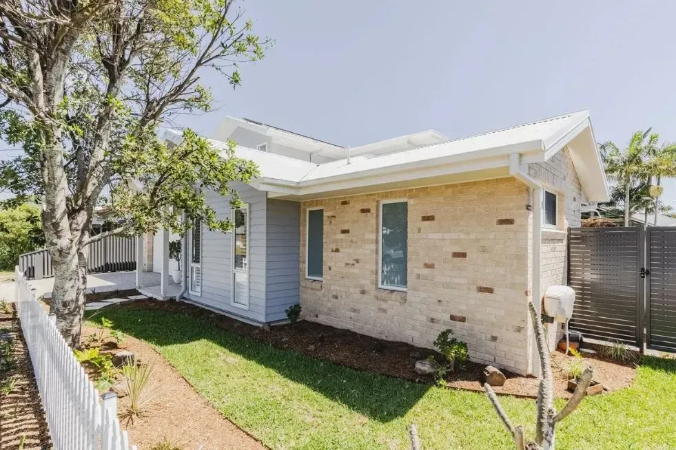 A Single-Story House with White Siding and Beige Stone Accents — Creative Landscapes Coffs Harbour in Korora, NSW