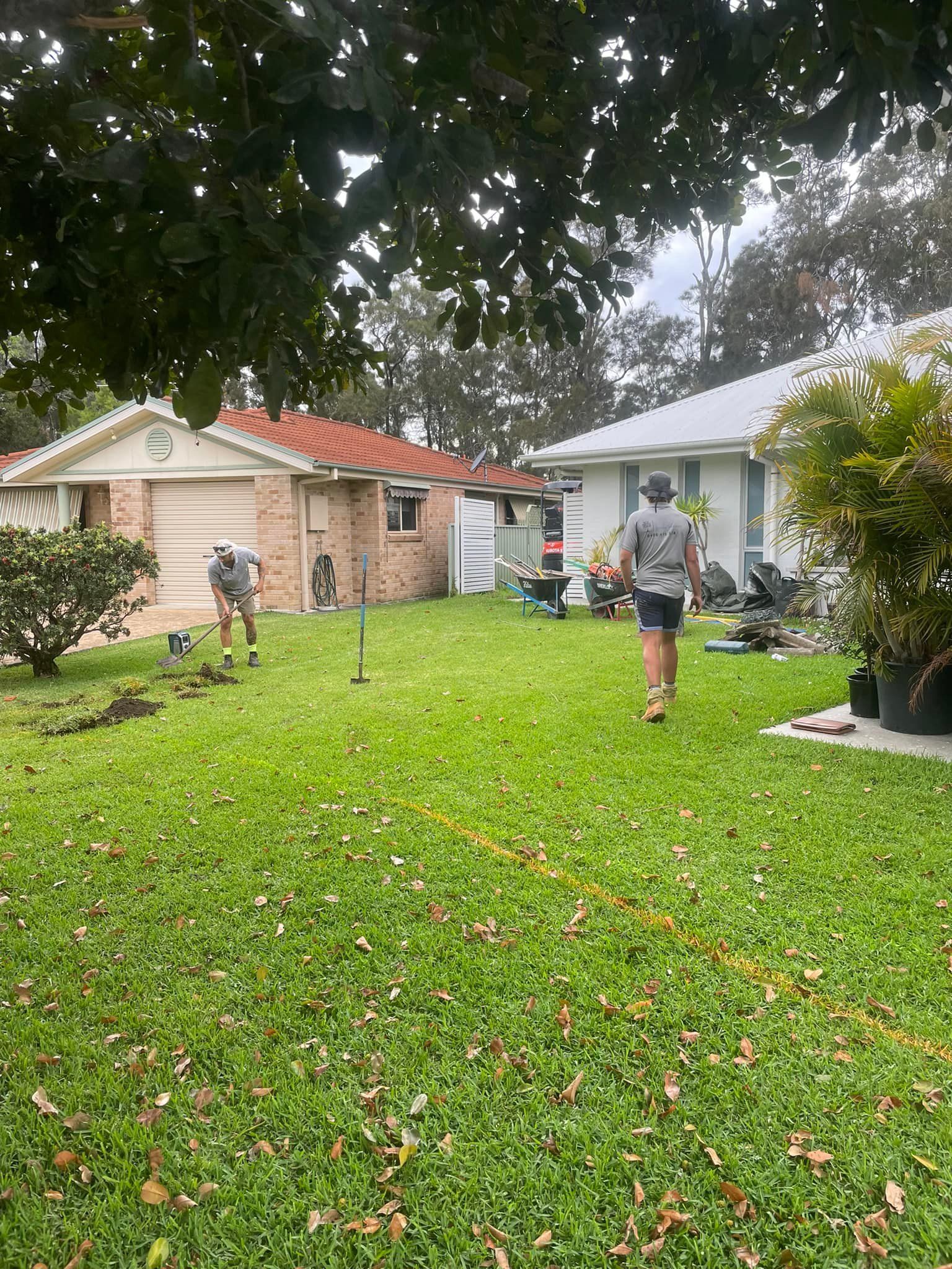 Two People Work in A Residential Backyard — Creative Landscapes Coffs Harbour in Korora, NSW