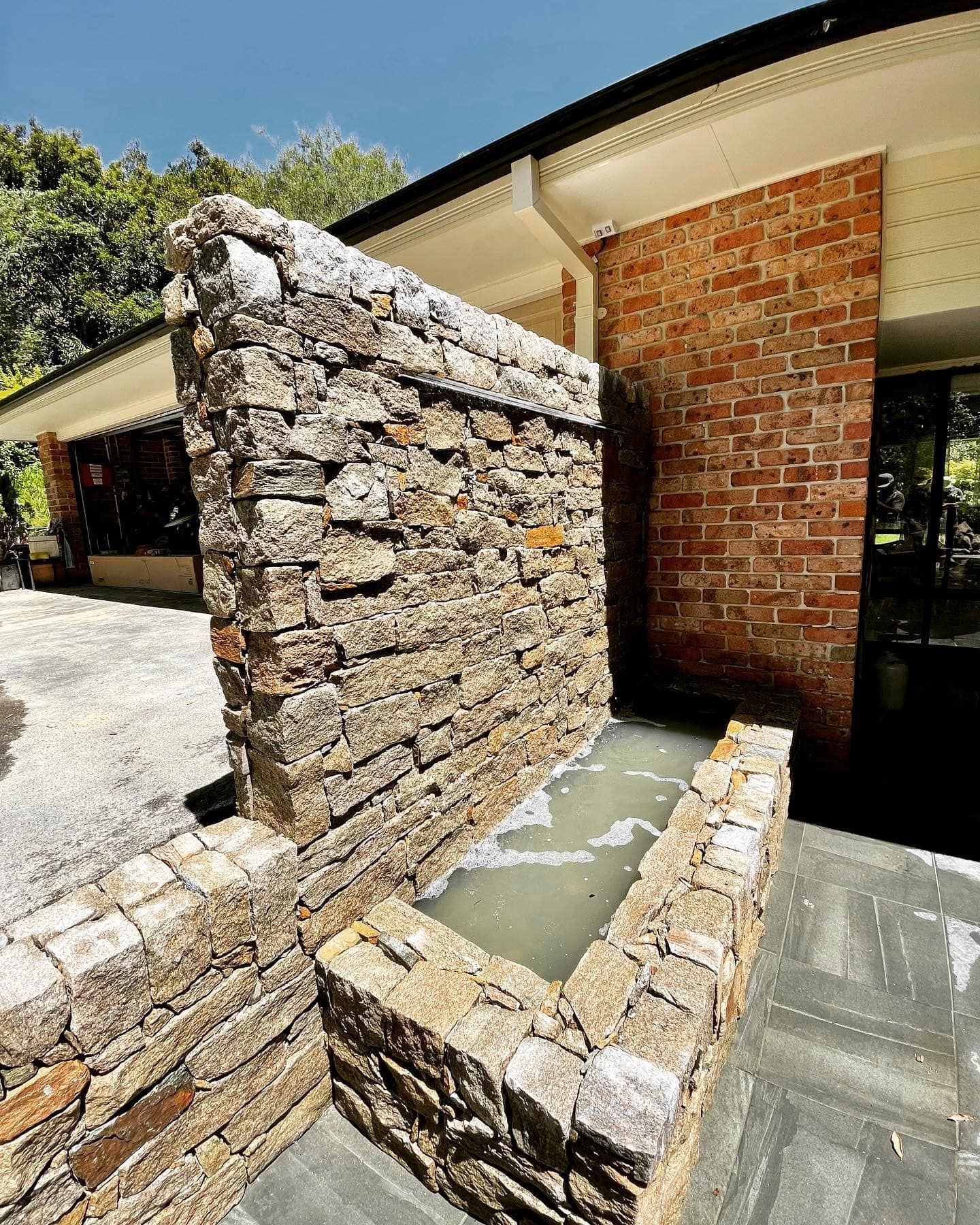 A Stone Waterfall Feature with A Basin Sits — Creative Landscapes Coffs Harbour in Korora, NSW