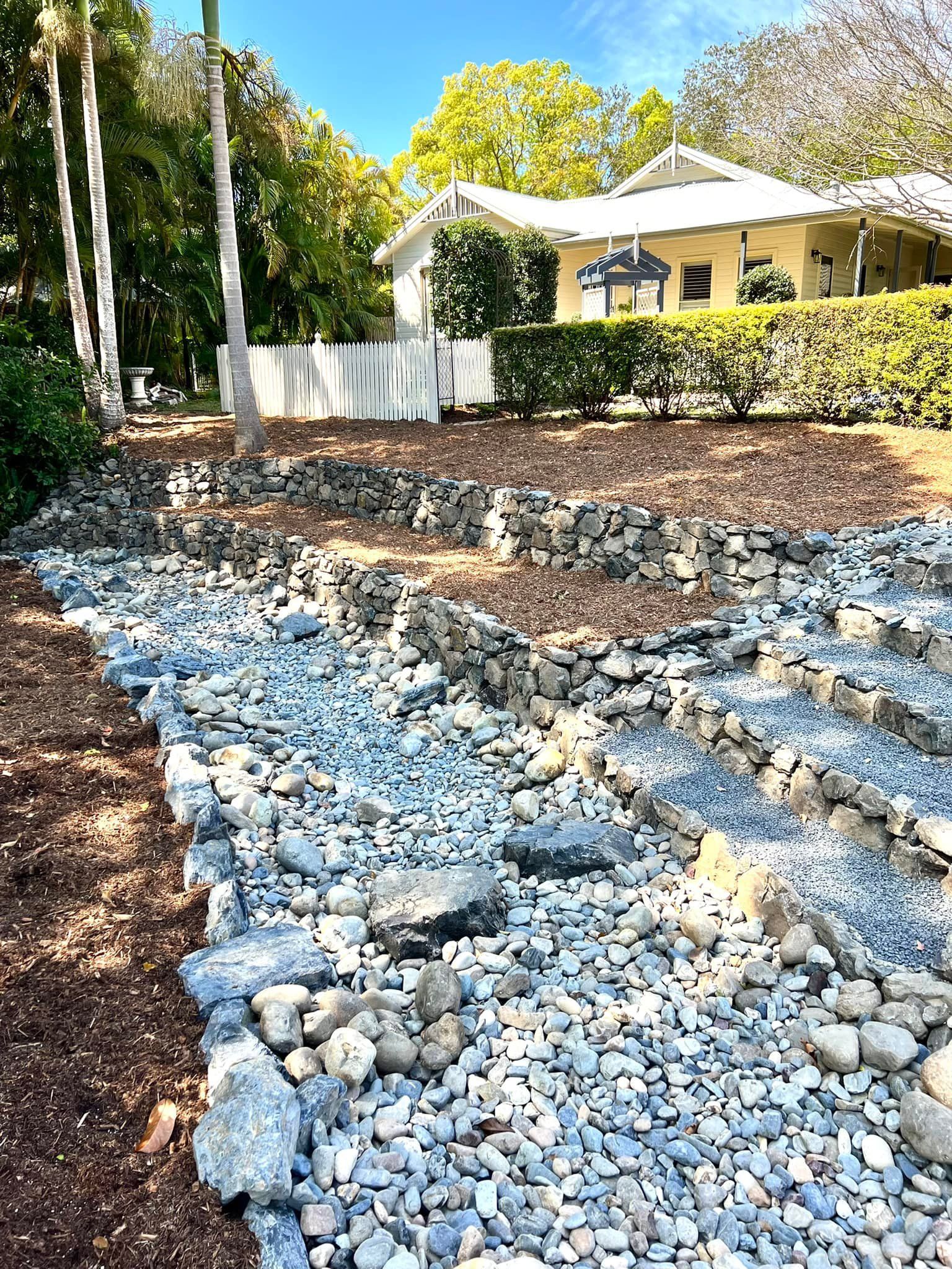A Stone-Lined Dry Creek Bed — Creative Landscapes Coffs Harbour in Sandy Beach, NSW