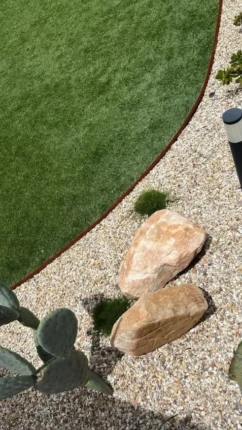 A Patch of Green Lawn Next to A Gravel Garden Bed — Creative Landscapes Coffs Harbour in Korora, NSW