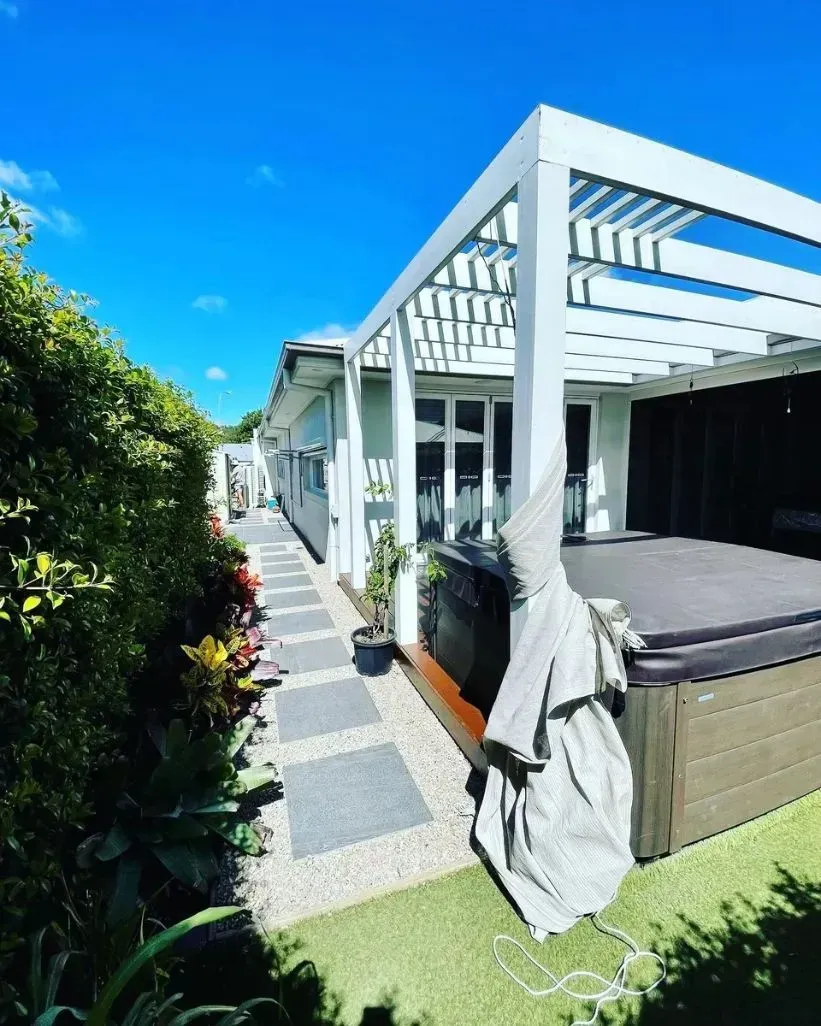 A Side Yard Featuring a White Pergola Over a Hot Tub — Creative Landscapes Coffs Harbour in Korora, NSW
