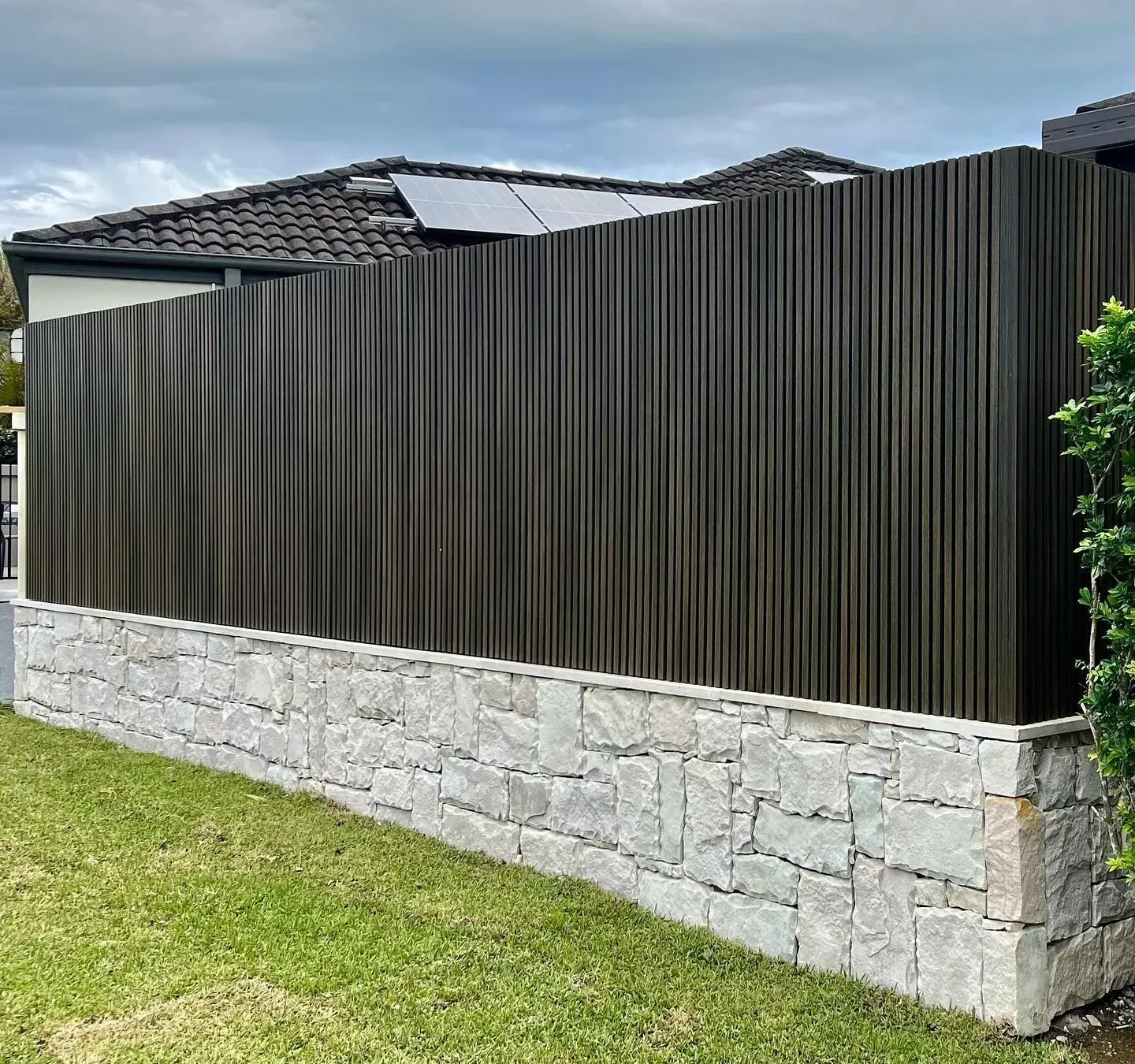 A Modern Fence Featuring Dark Vertical Wooden Slats  — Creative Landscapes Coffs Harbour in Korora, NSW