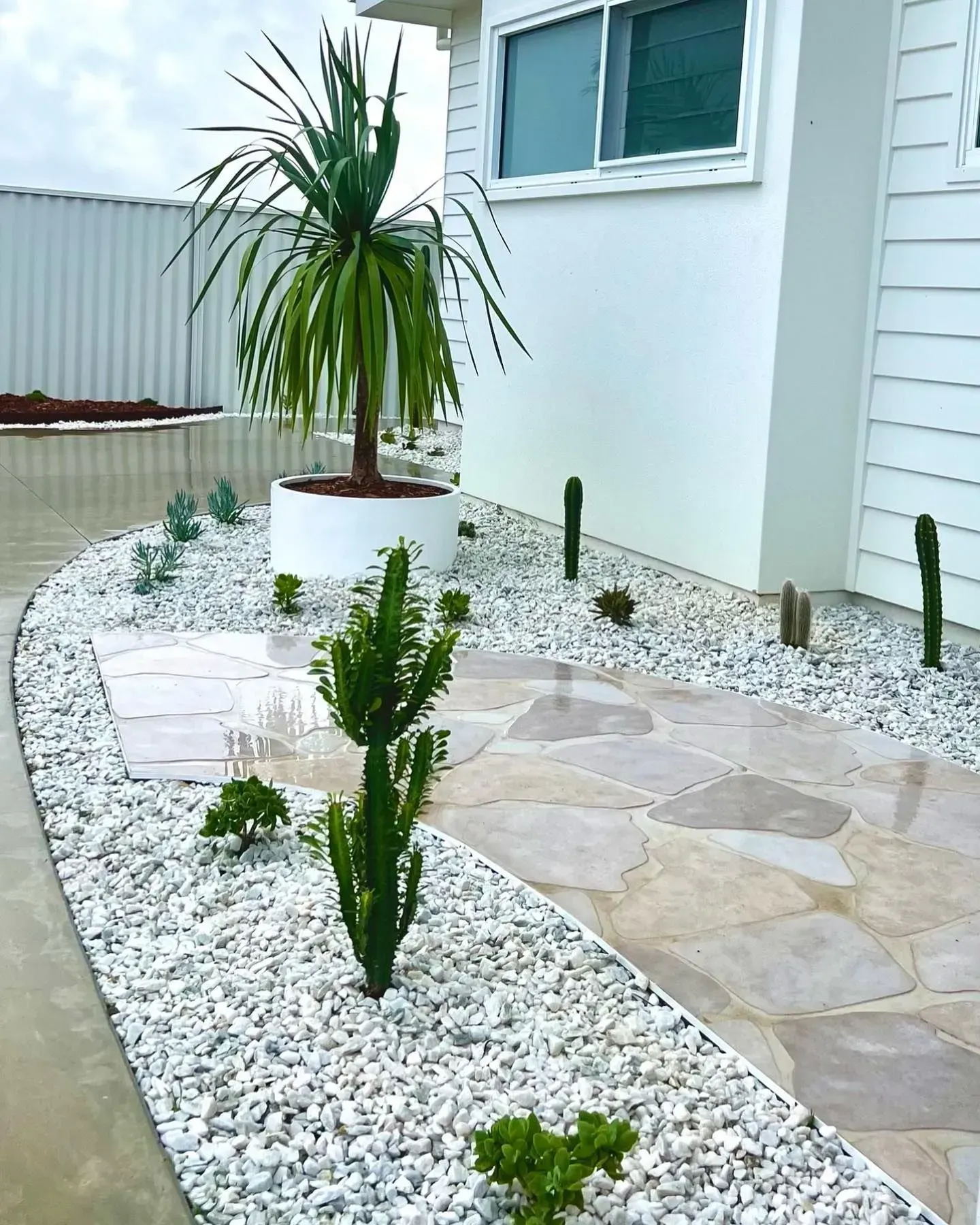 A Flagstone Pathway Leads Past a White Planter  — Creative Landscapes Coffs Harbour in Korora, NSW