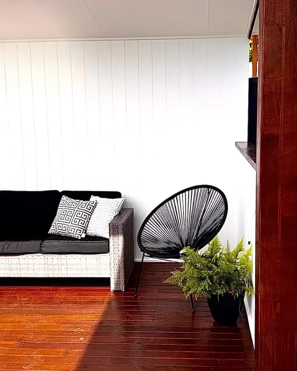 A Modern Outdoor Lounge with A Black Sofa — Creative Landscapes Coffs Harbour in Korora, NSW