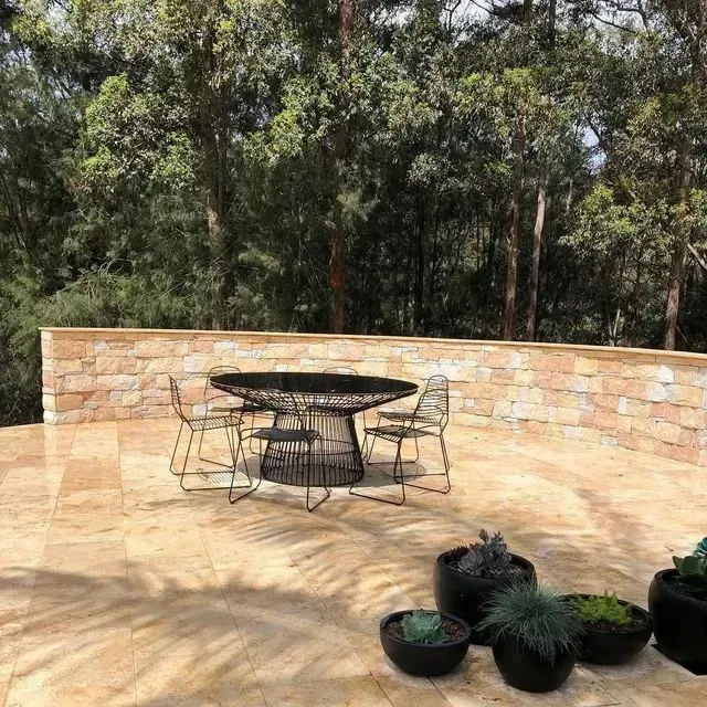 A Patio with A Round Black Dining Table and Chairs — Creative Landscapes Coffs Harbour in Sapphire Beach, NSW