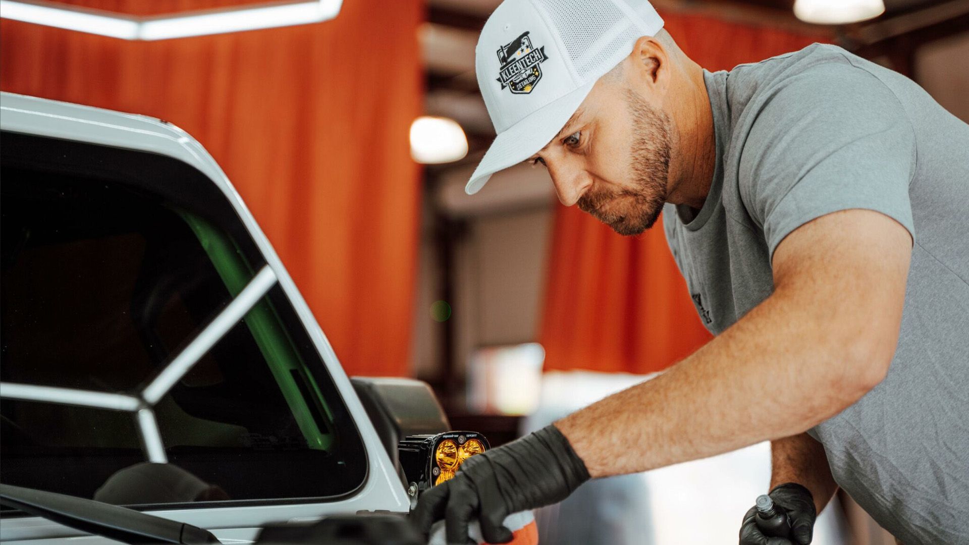 A man is working on a car in a garage.