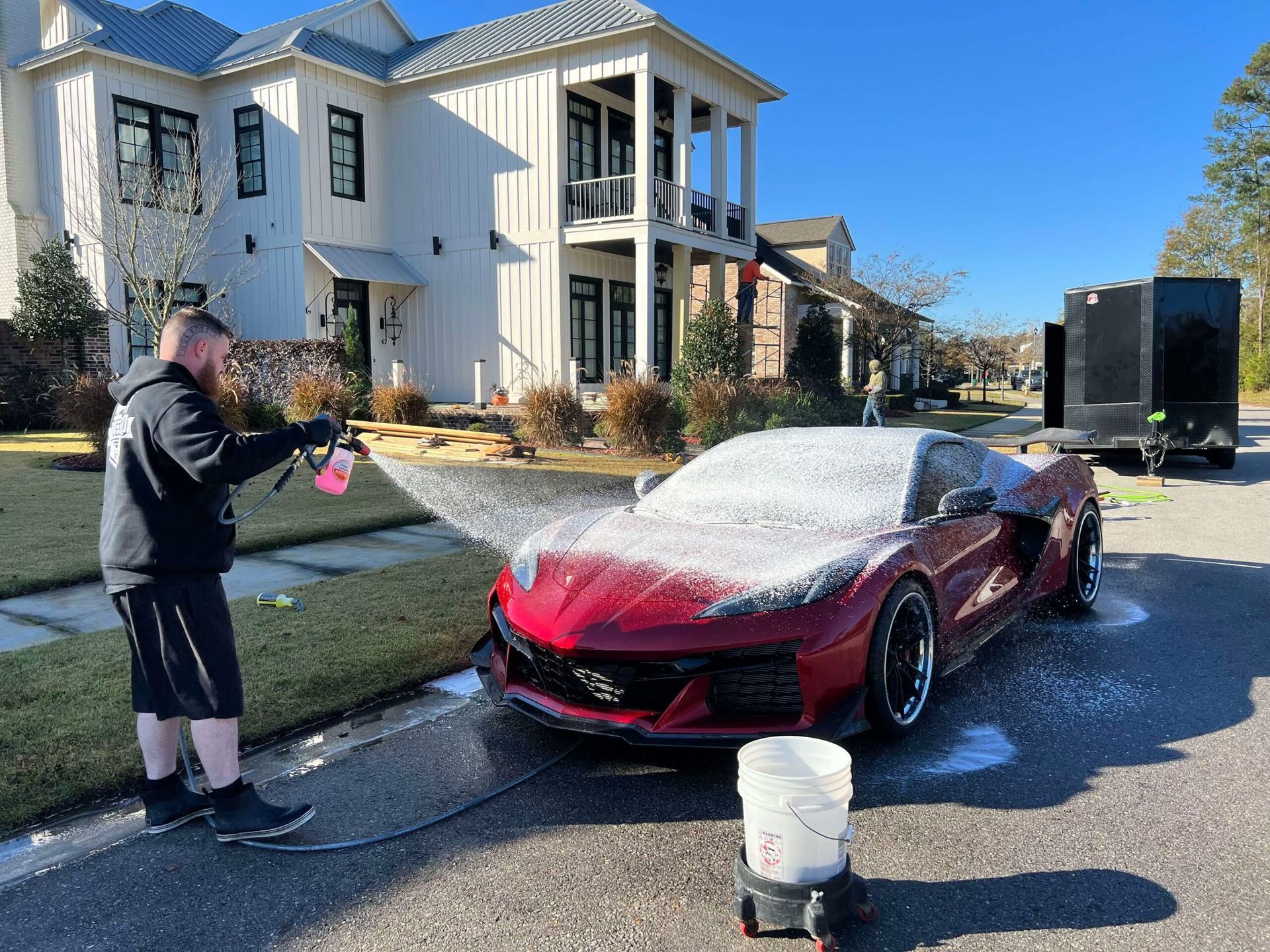 Silver Porsche covered in foam being washed in a car wash bay