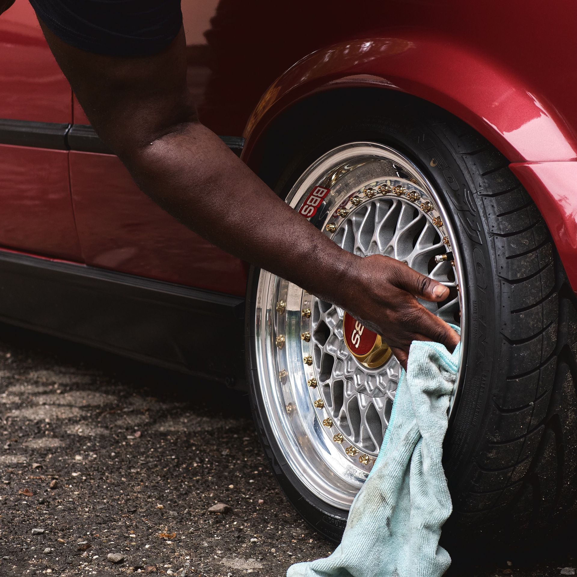 Silver Porsche covered in foam being washed in a car wash bay