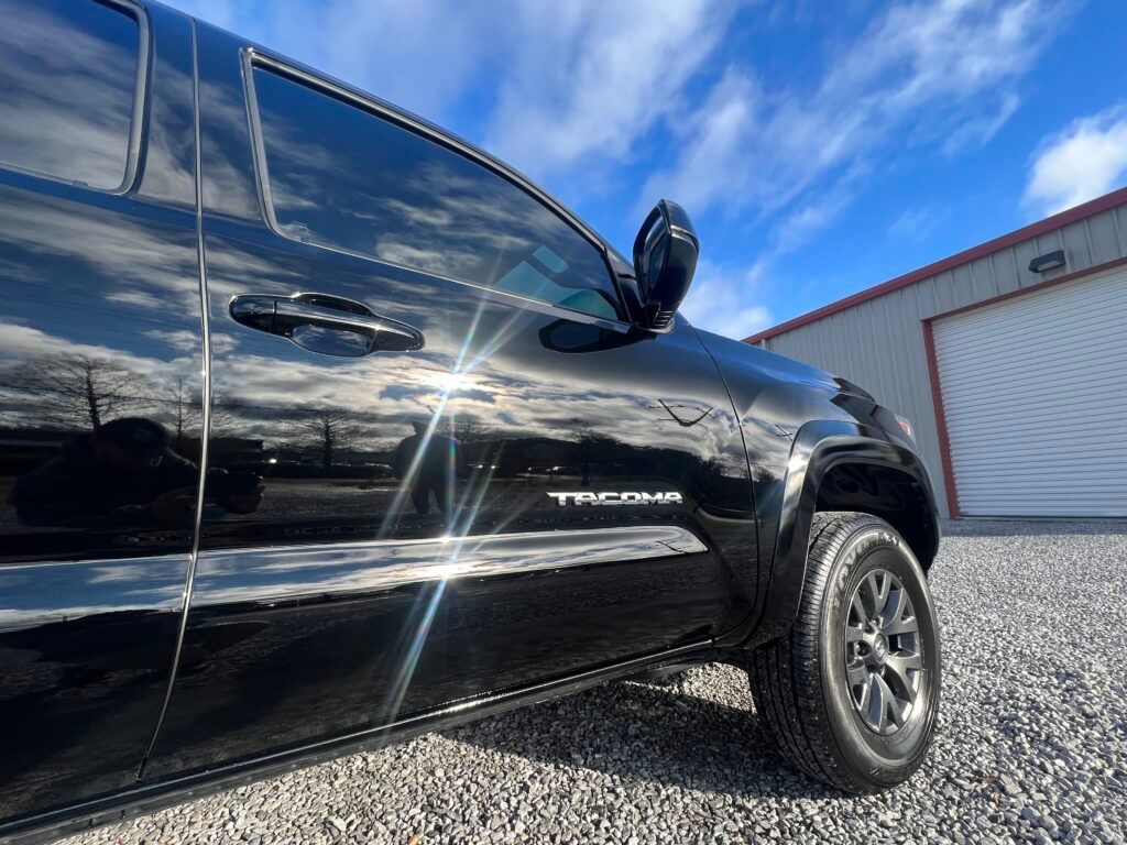 A black truck is parked in front of a garage.