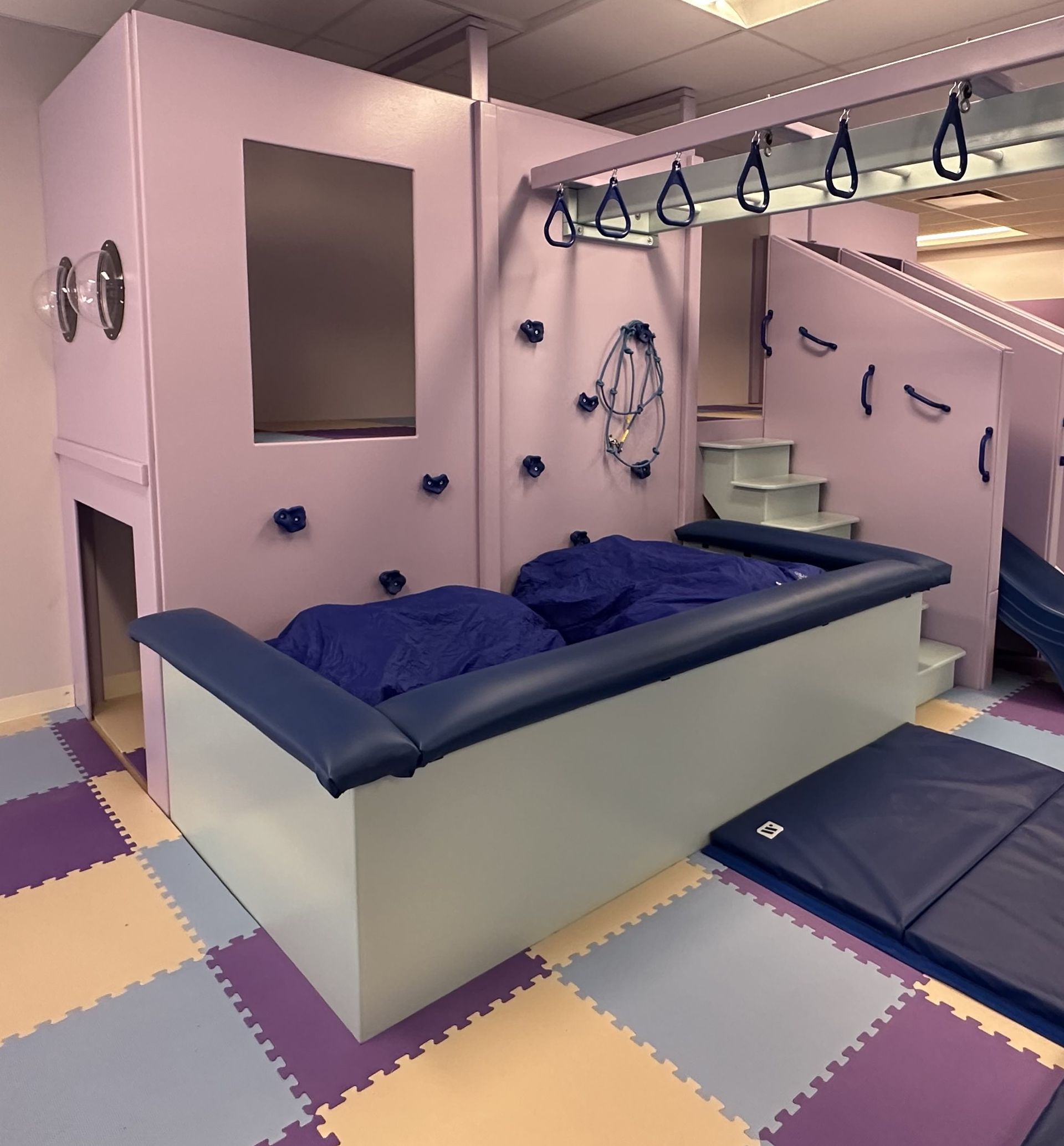 Custom sensory gym crash pit with a high padded perimeter for supervised movement activities