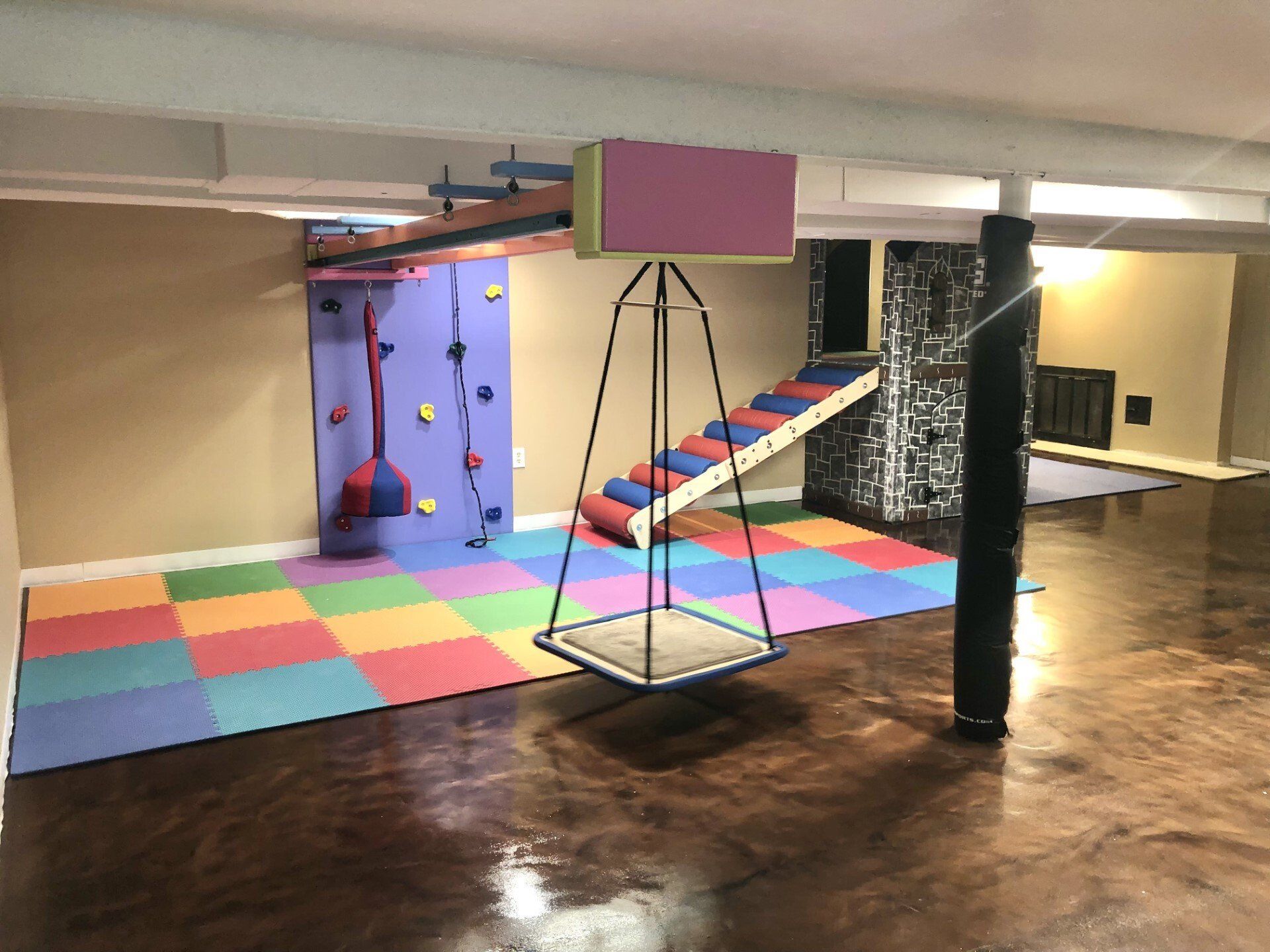 Custom castle sensory gym structure with slide, climbing features, and padded sensory play area