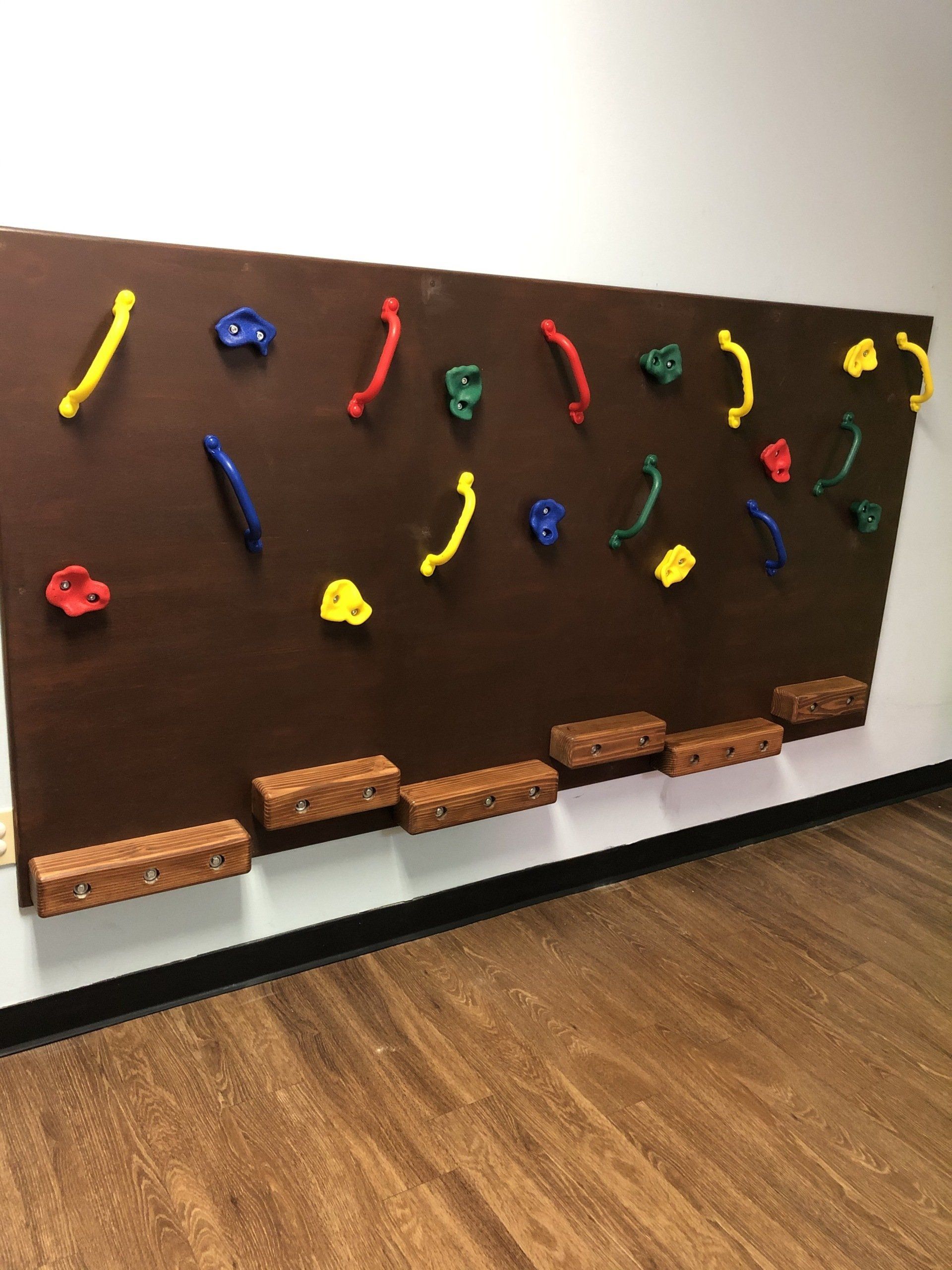 Sensory wall activity panel with colorful climbing holds for coordination, grip strength, and movement play