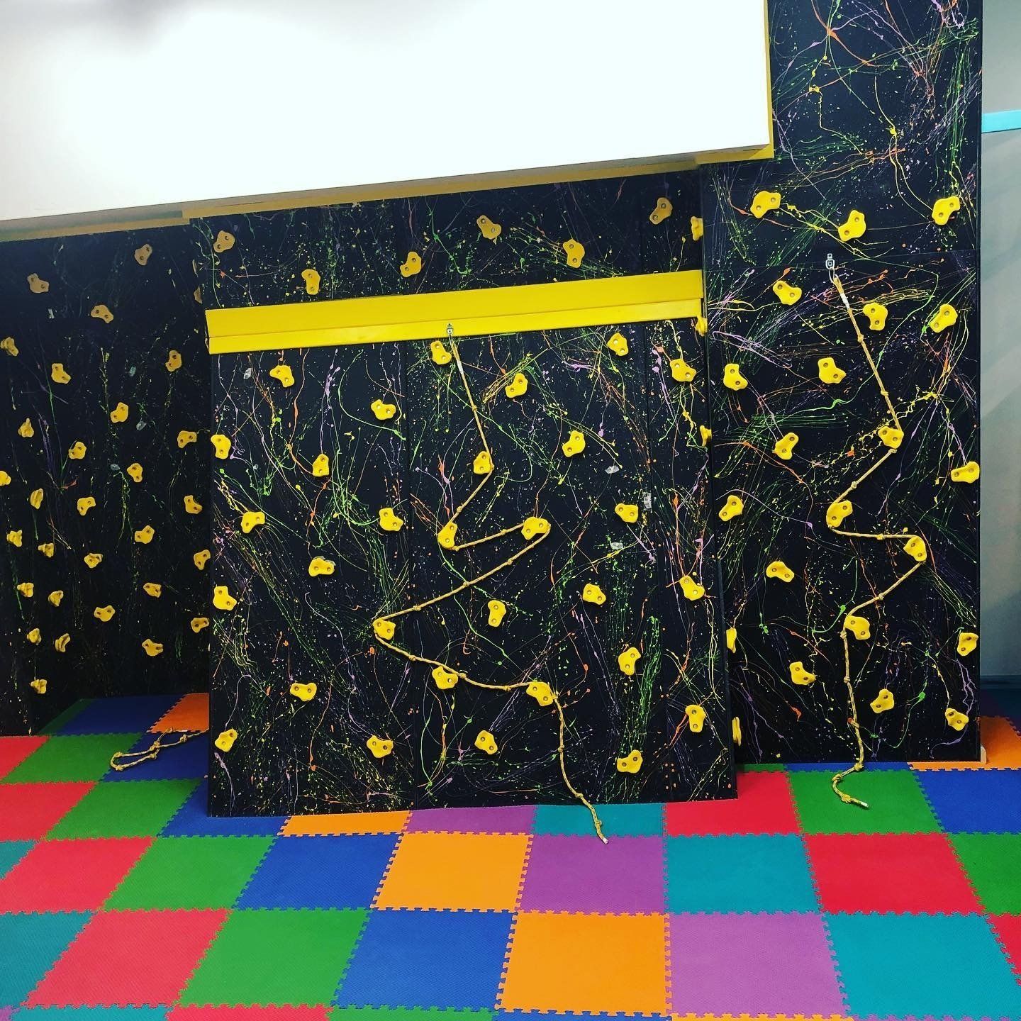 Indoor sensory gym climbing wall with colorful handholds for movement, coordination, and sensory play