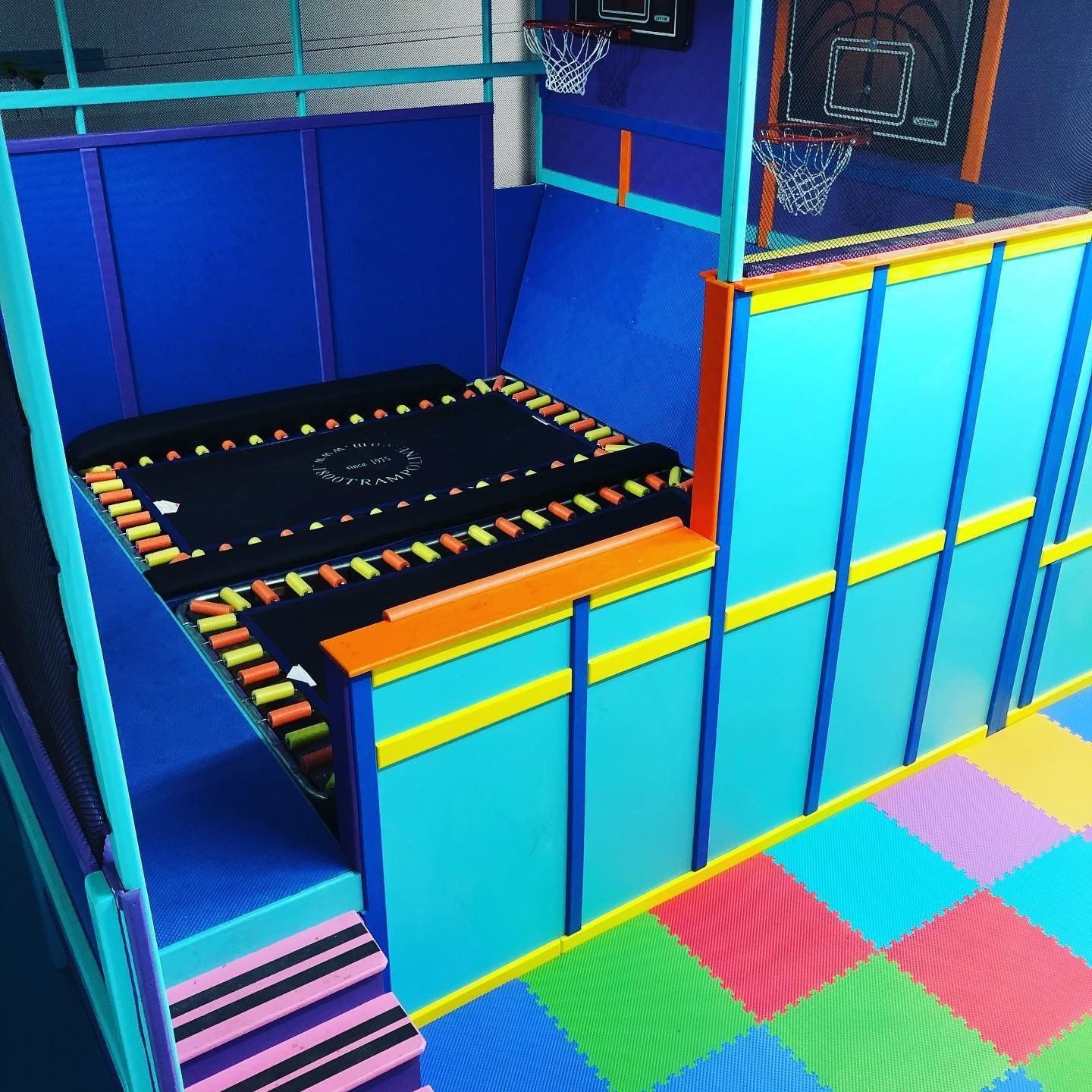 Custom sensory trampoline enclosure with padded walls, protective netting, and an indoor movement area
