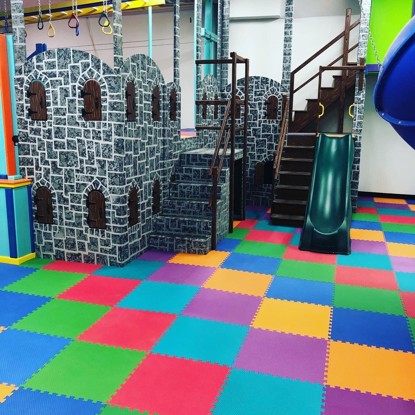 Custom castle sensory gym structure with slide, climbing features, and padded indoor play area
