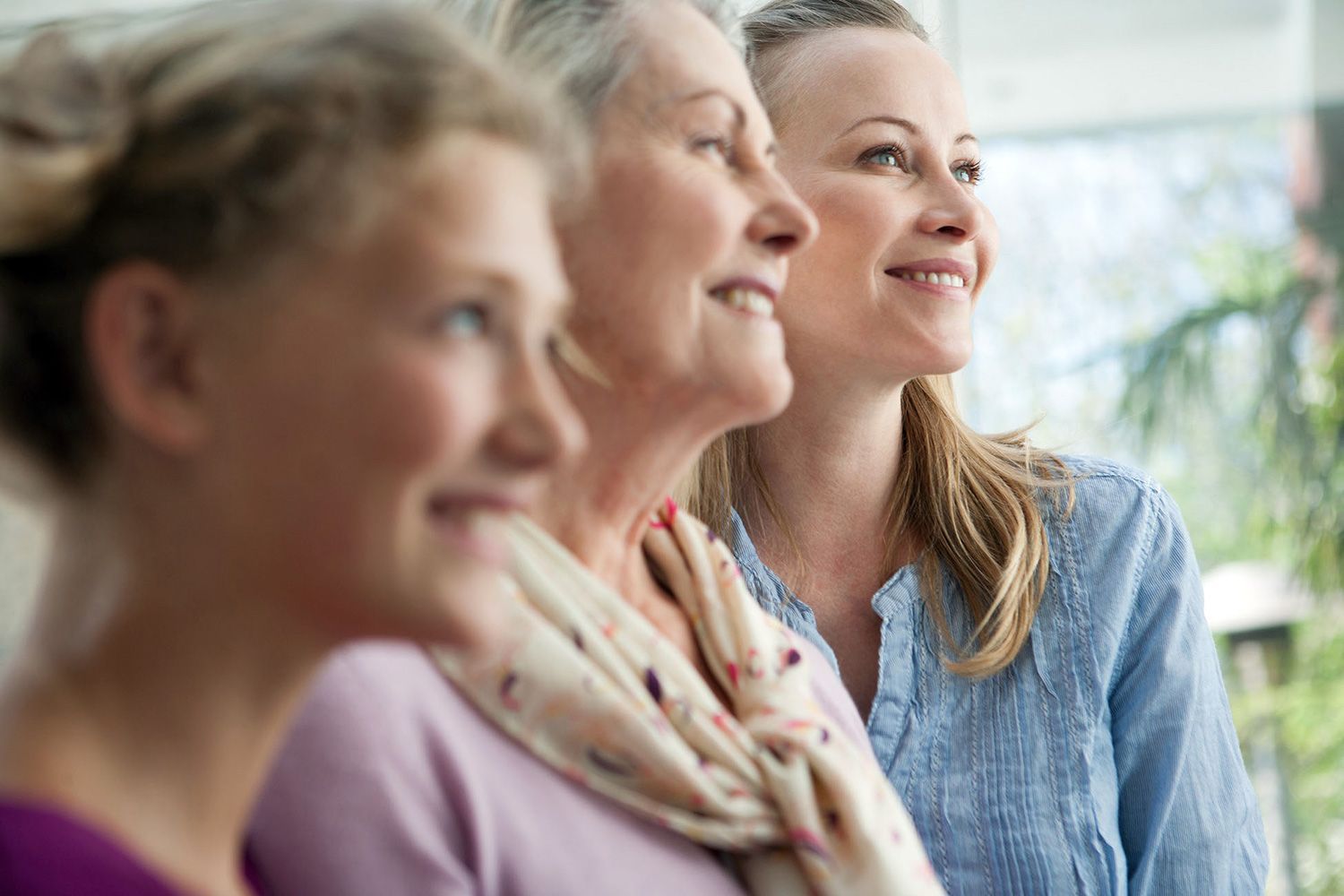Tre donne sono sedute una accanto all'altra e sorridono.
