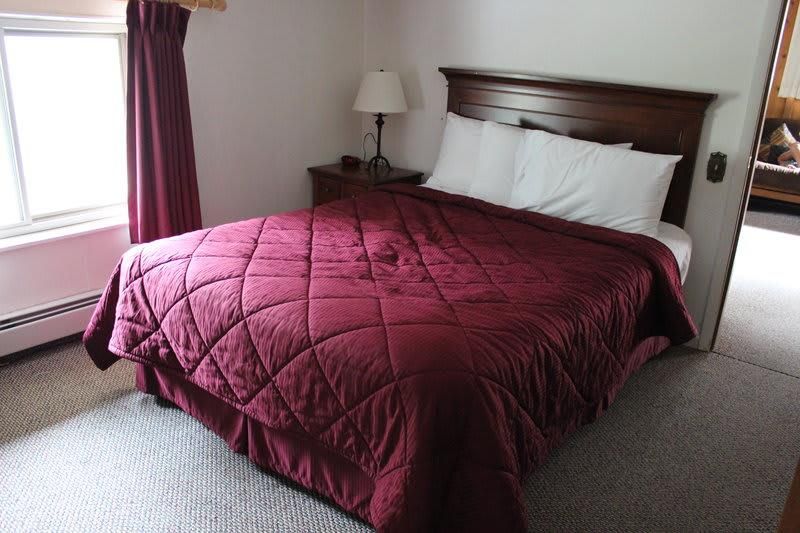 A hotel room with a bed and a lamp