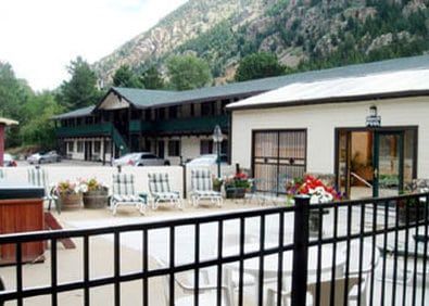 A motel with a hot tub and a table and chairs in front of it.