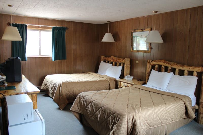 A hotel room with two beds and a refrigerator