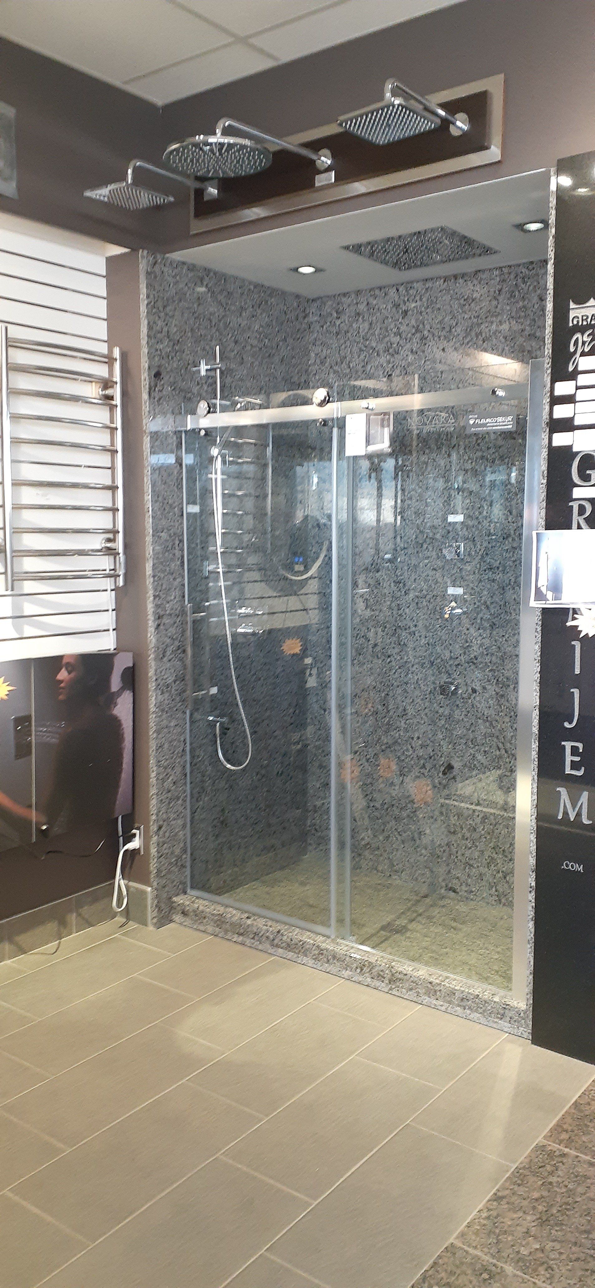 Une cabine de douche avec portes coulissantes en verre dans une salle de bain.
