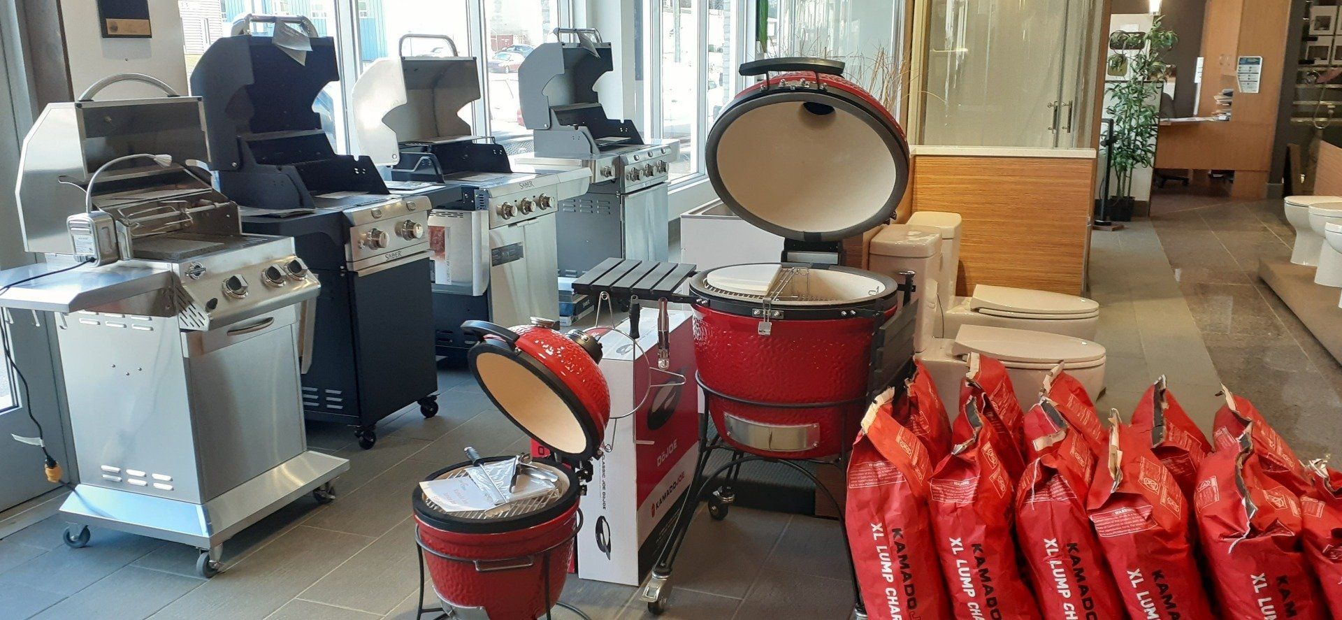 Un magasin rempli de nombreux grils et de sacs de charbon de bois.