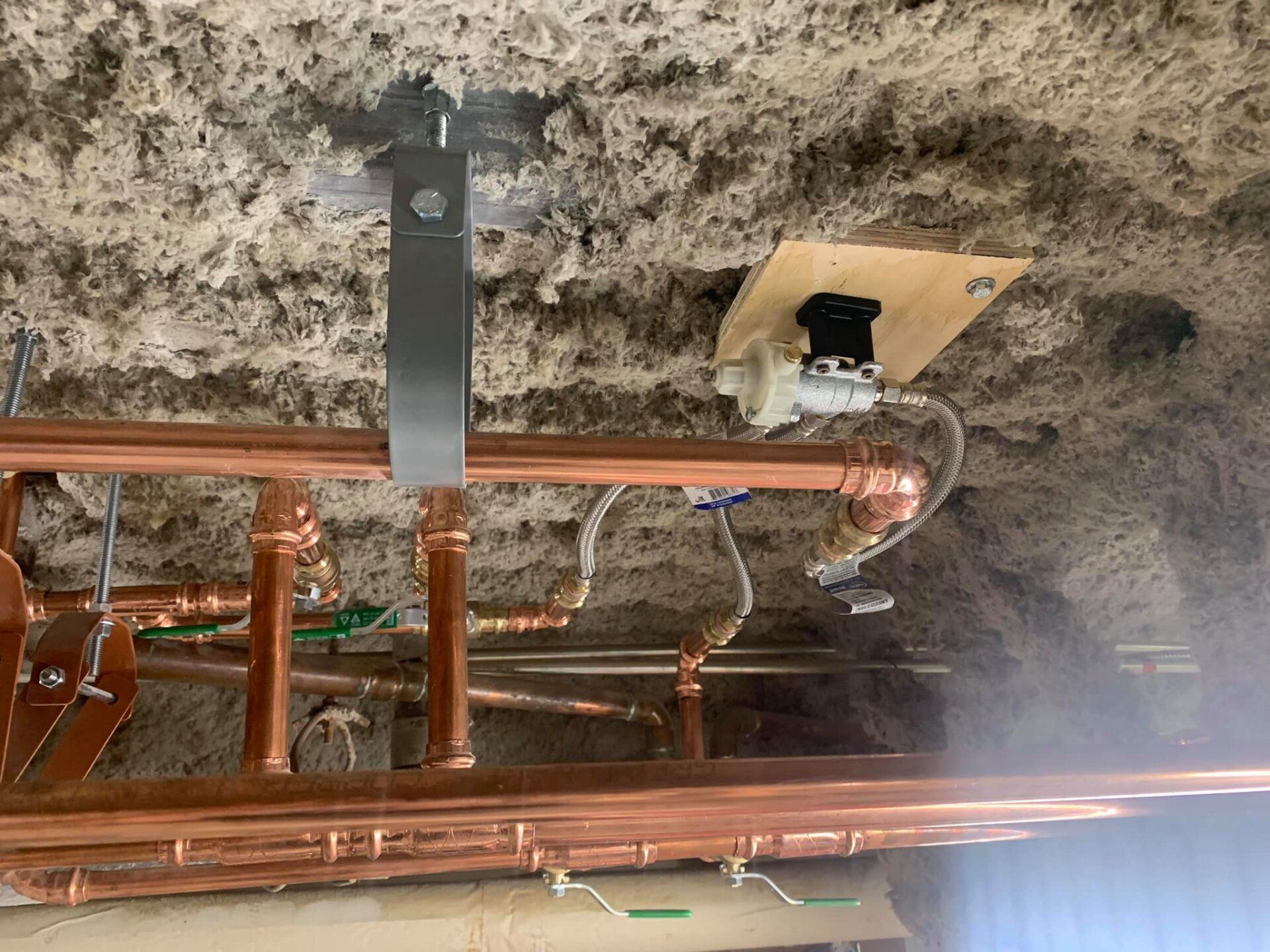 Un tas de tuyaux en cuivre pendent du plafond.