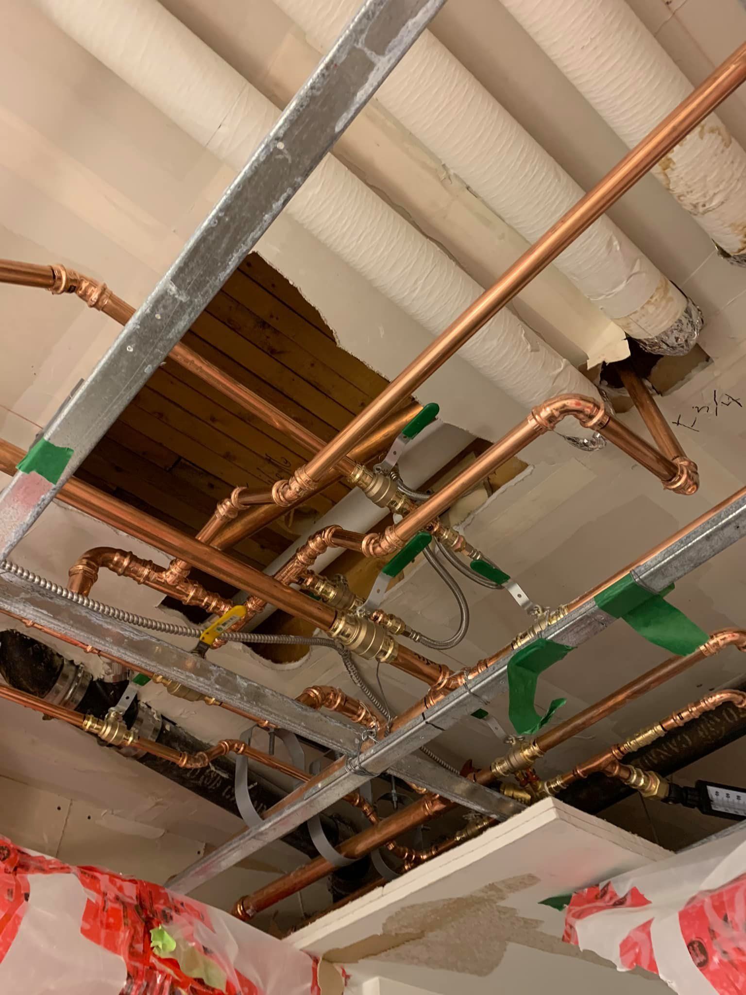 Un tas de tuyaux en cuivre pendent du plafond d'un bâtiment.