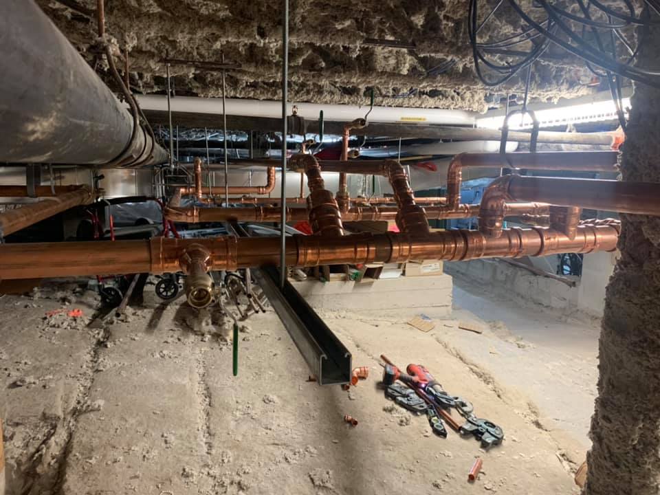 Une pièce avec beaucoup de tuyaux suspendus au plafond.